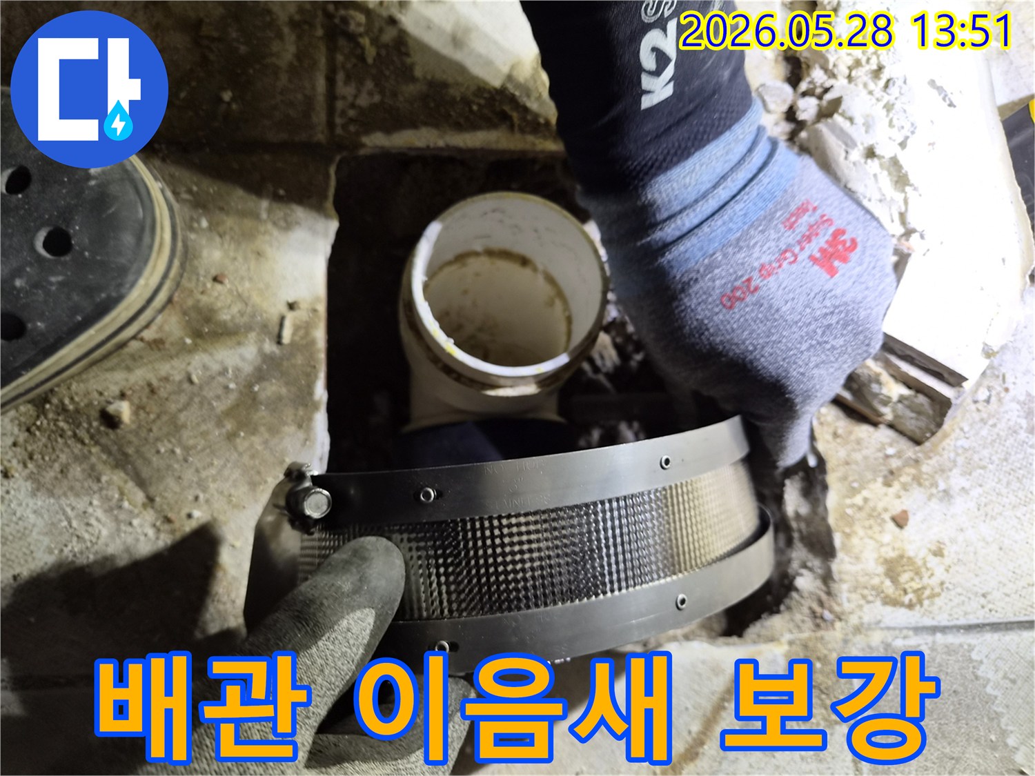 숙련된 작업자가 보호 장갑을 착용하고-배관의 취약한 연결 부위에-보강 밴드를 설치하는 중입니다
