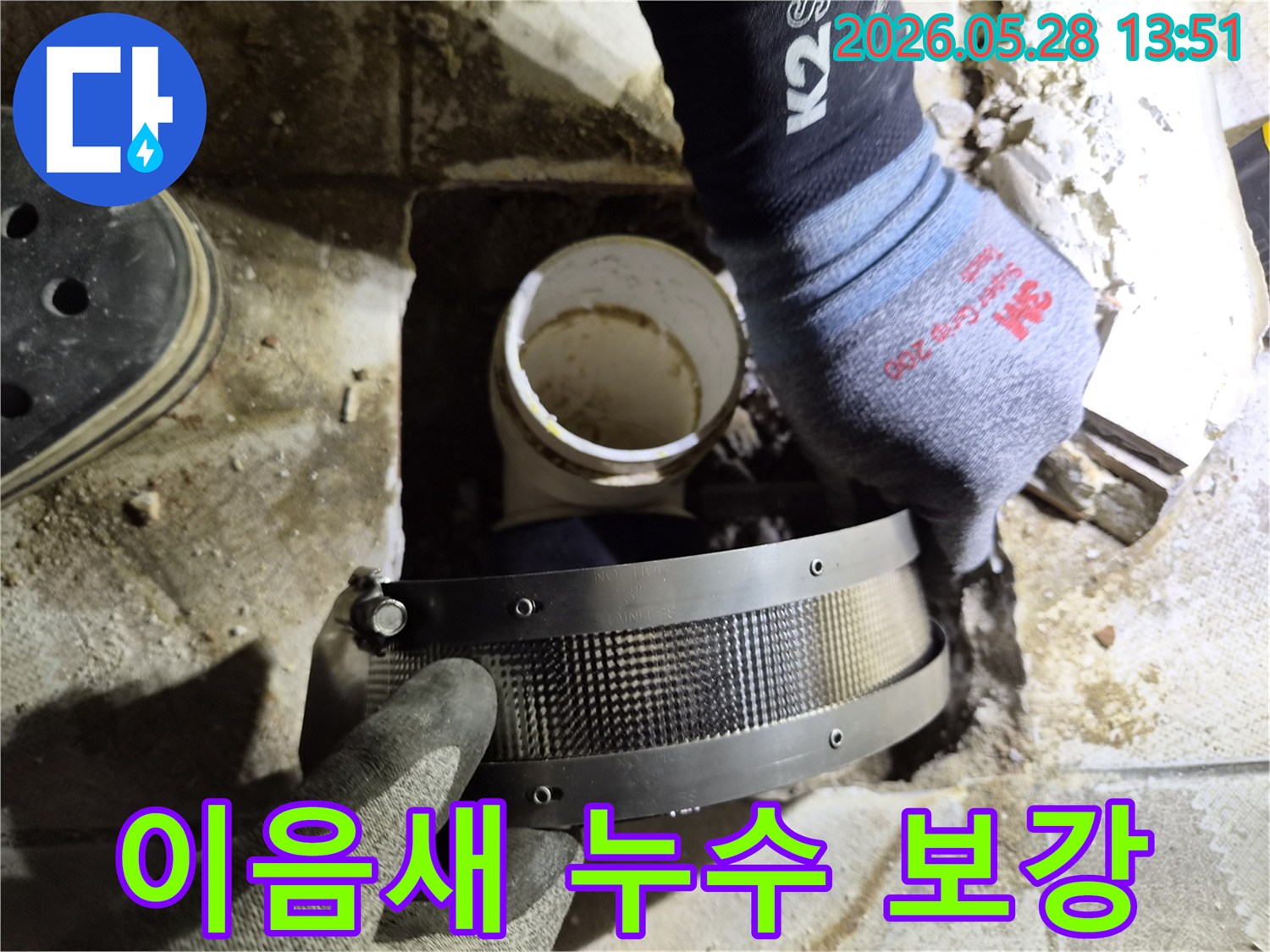전문가가 작업용 장갑을 끼고-아파트 배관의 이음새 누수 지점에-보강 밴드를 적용하는 모습입니다