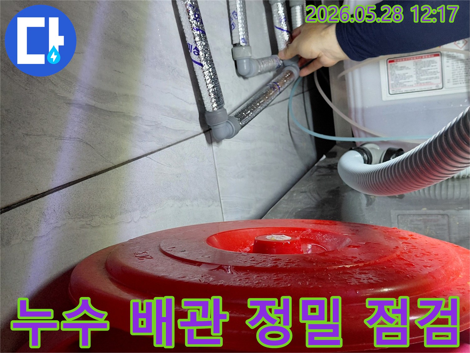숙련된 엔지니어가-젖은 바닥과-연결된 배관들을-정밀하게 점검하여-누수 지점을-찾아내고 있습니다.