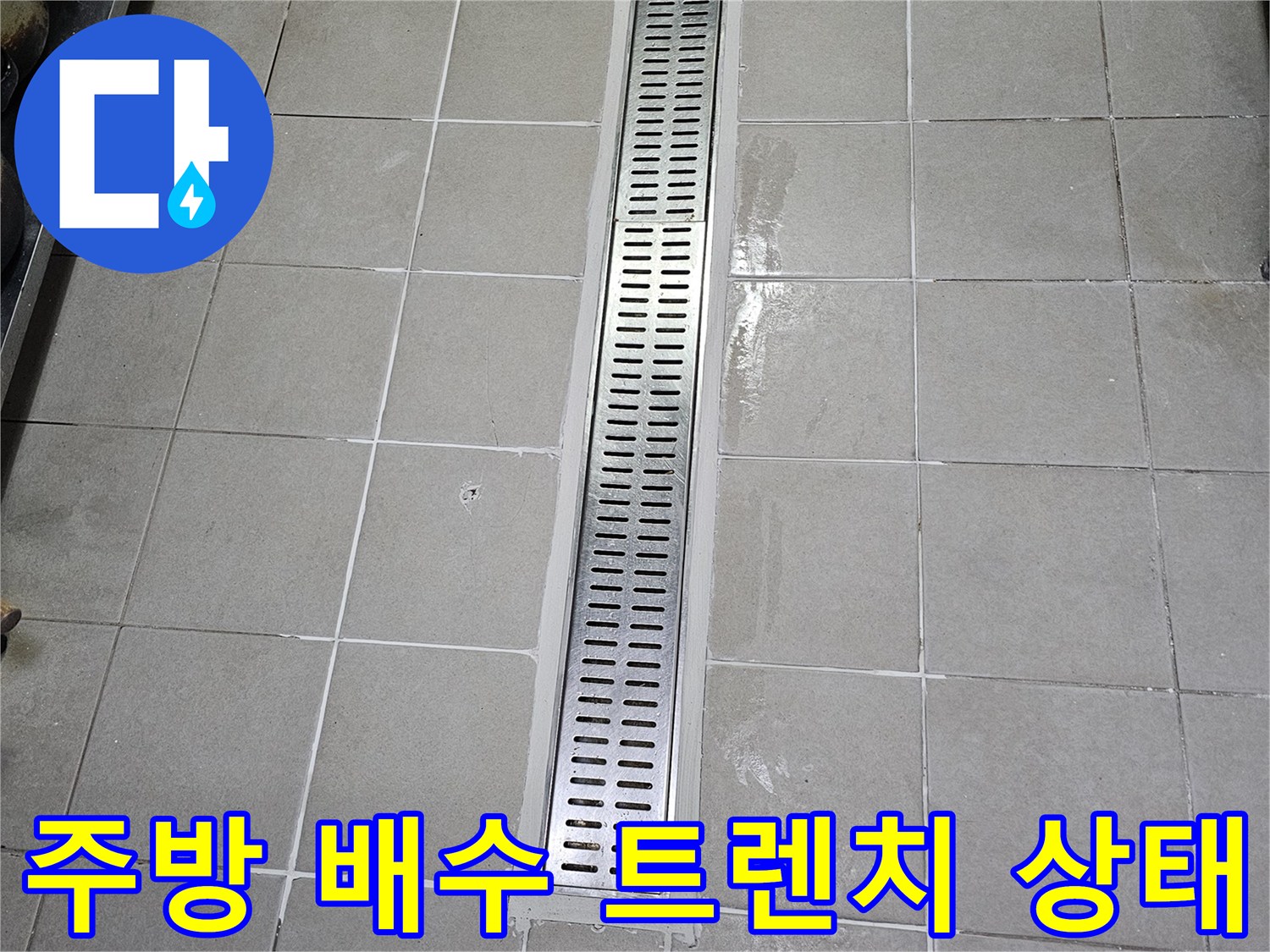 식당 주방의 스테인리스 배수 트렌치와 타일 접합부 모습