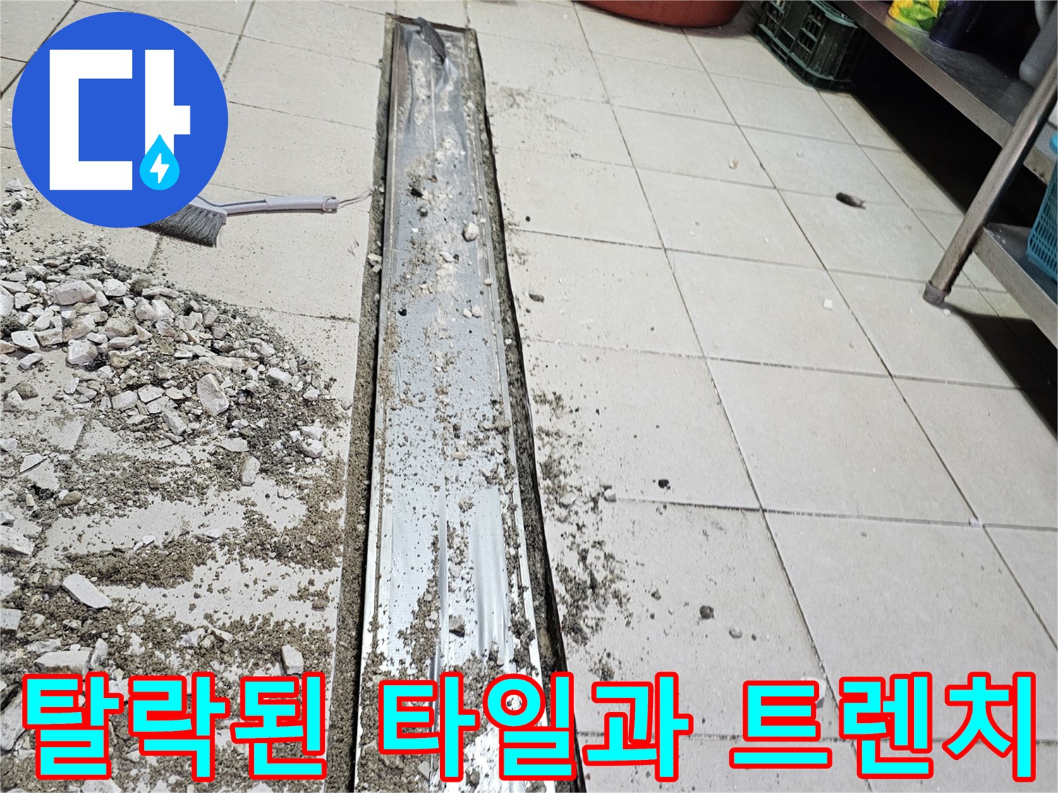트렌치 주변에 흩어진 깨진 타일 조각과 콘크리트 가루