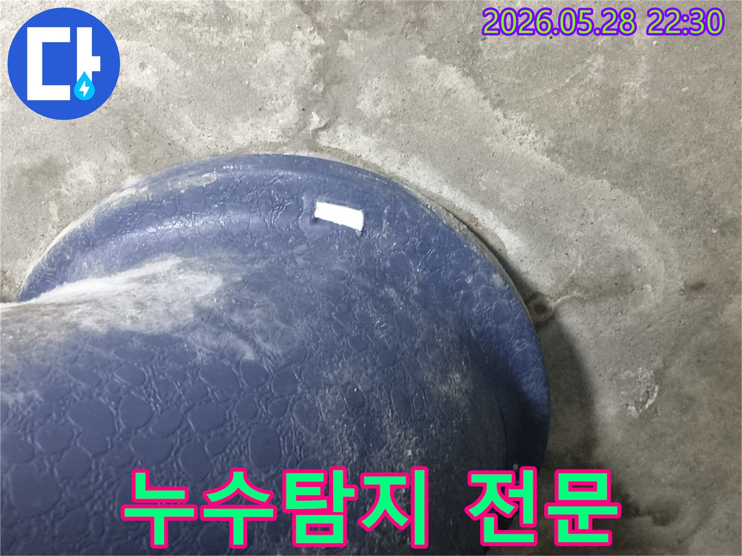 콘크리트 바닥의-파란색 배관-주변에-물이-새어-나와-젖은-모습을-보여주는-누수-탐지-전문업체의-현장-사진
