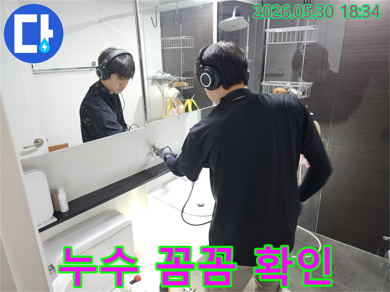 누수-탐지-전문가가-헤드셋으로-배관의-미세한-소리를-듣고-있는-현장-사진