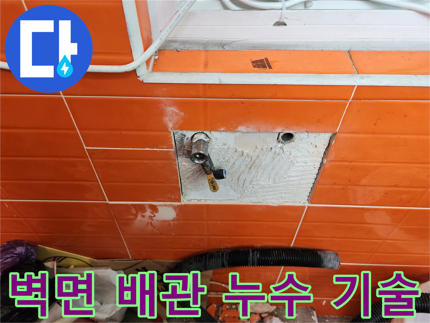 오렌지색 타일 벽면의-배관 누수를-전문 기술로 해결하기 위해-타일을 제거하고-배관을 수리하는 작업 현장