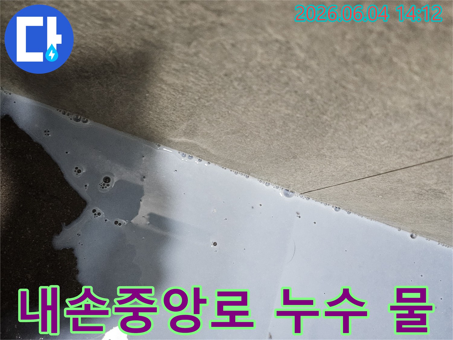 의왕시 내손중앙로에서 발생한 누수로-바닥에 물이 고여있는 현장을 보여줍니다.