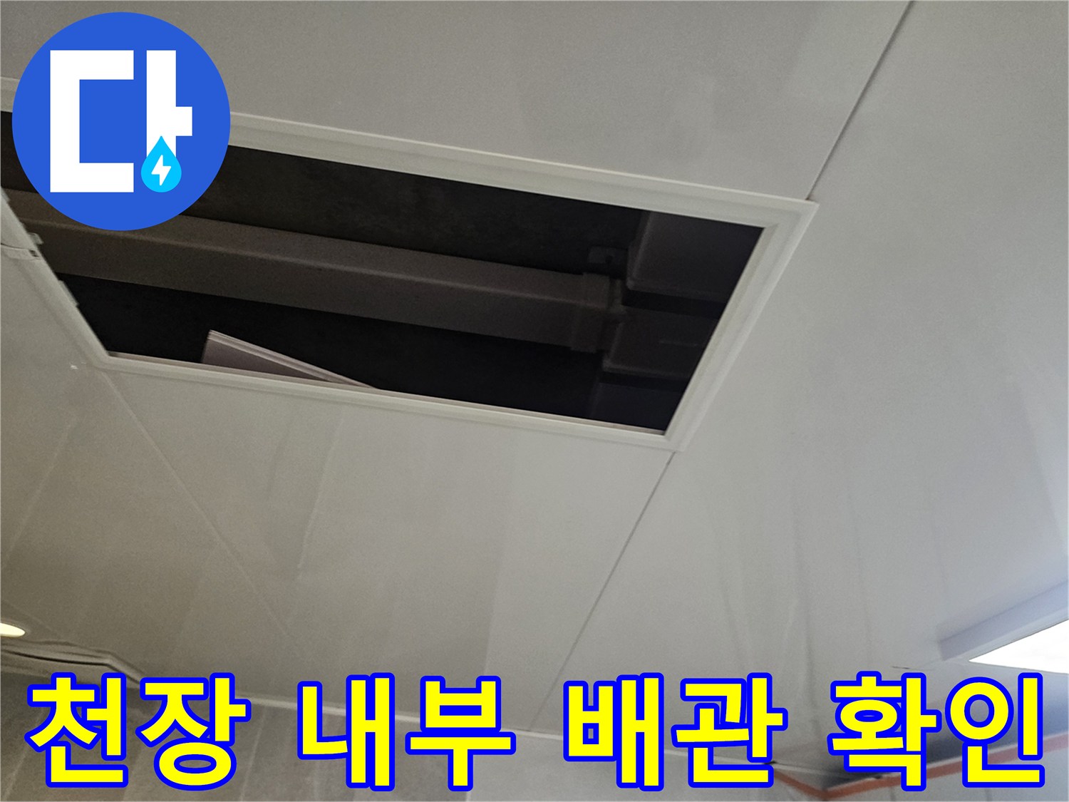 천장 점검구 너머로 보이는 배관과 내부 공간의 모습입니다.