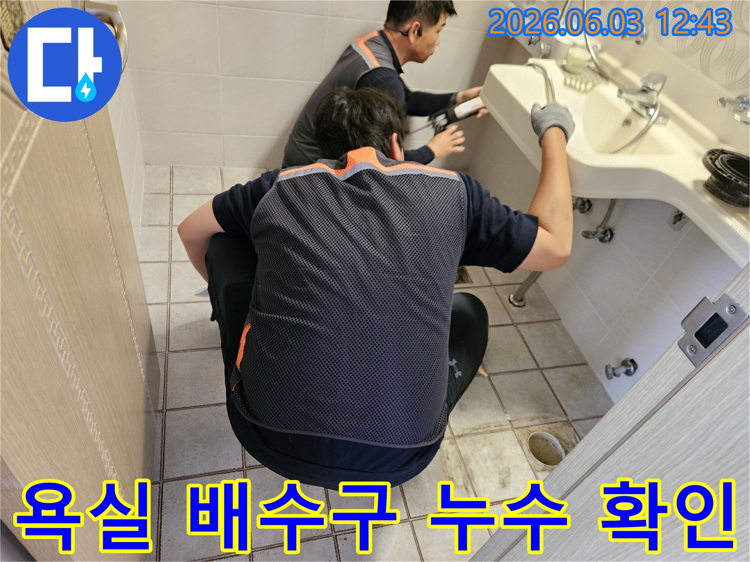 서울 중랑구 주택 욕실에서-두 명의 누수 전문가가-배수구 주변의 누수 여부를-정밀하게 확인하는 모습