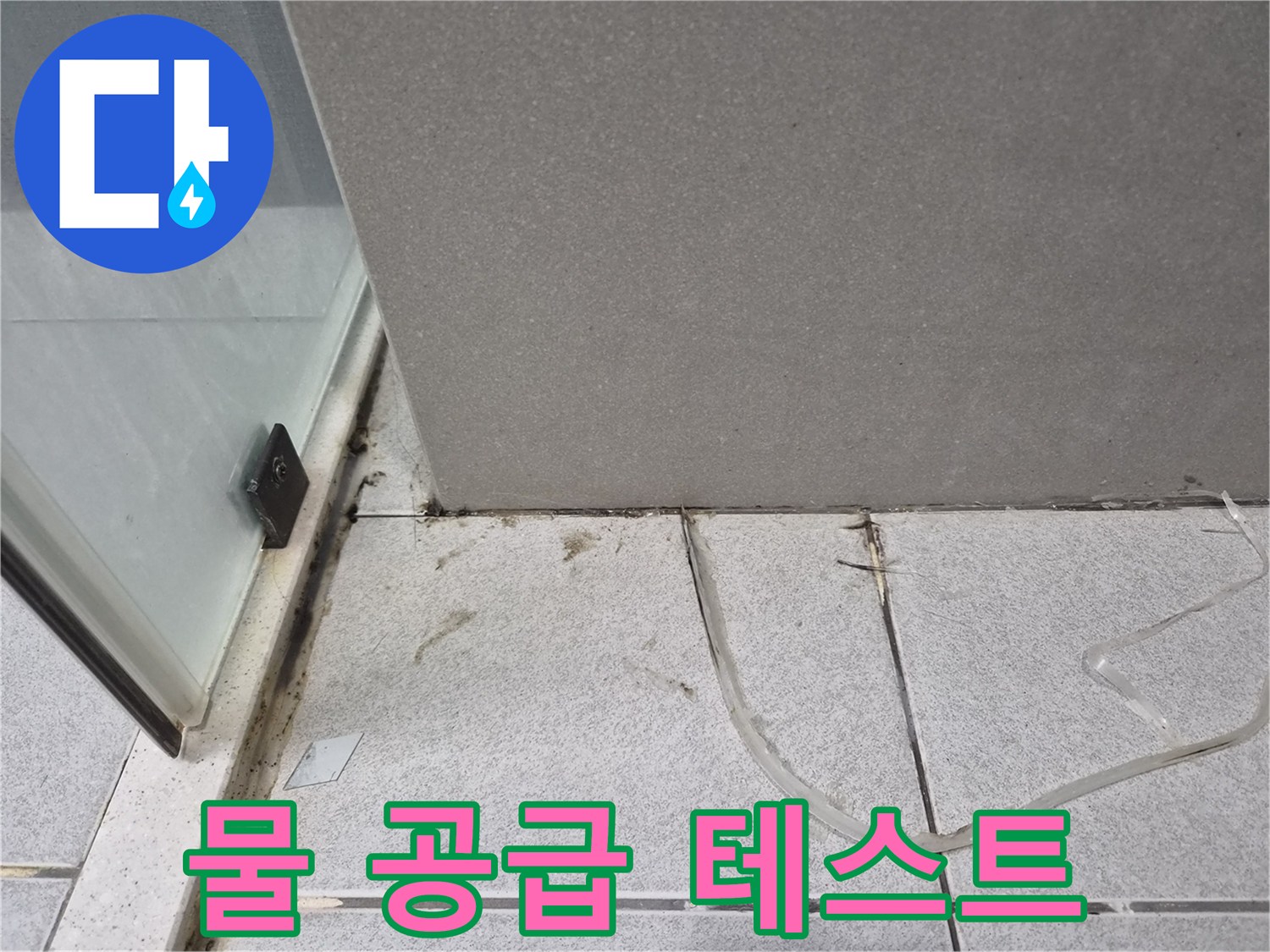 욕실-바닥에-놓인-튜브를-이용하여-누수-지점을-정확히-확인하기-위한-물-공급-테스트를-진행하는-모습