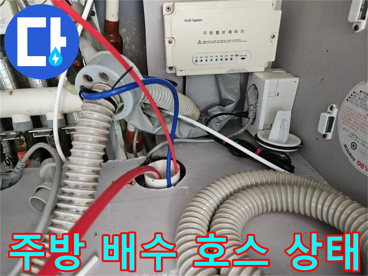 싱크대 하부 연결된 굵은 주름관과 주변 배선