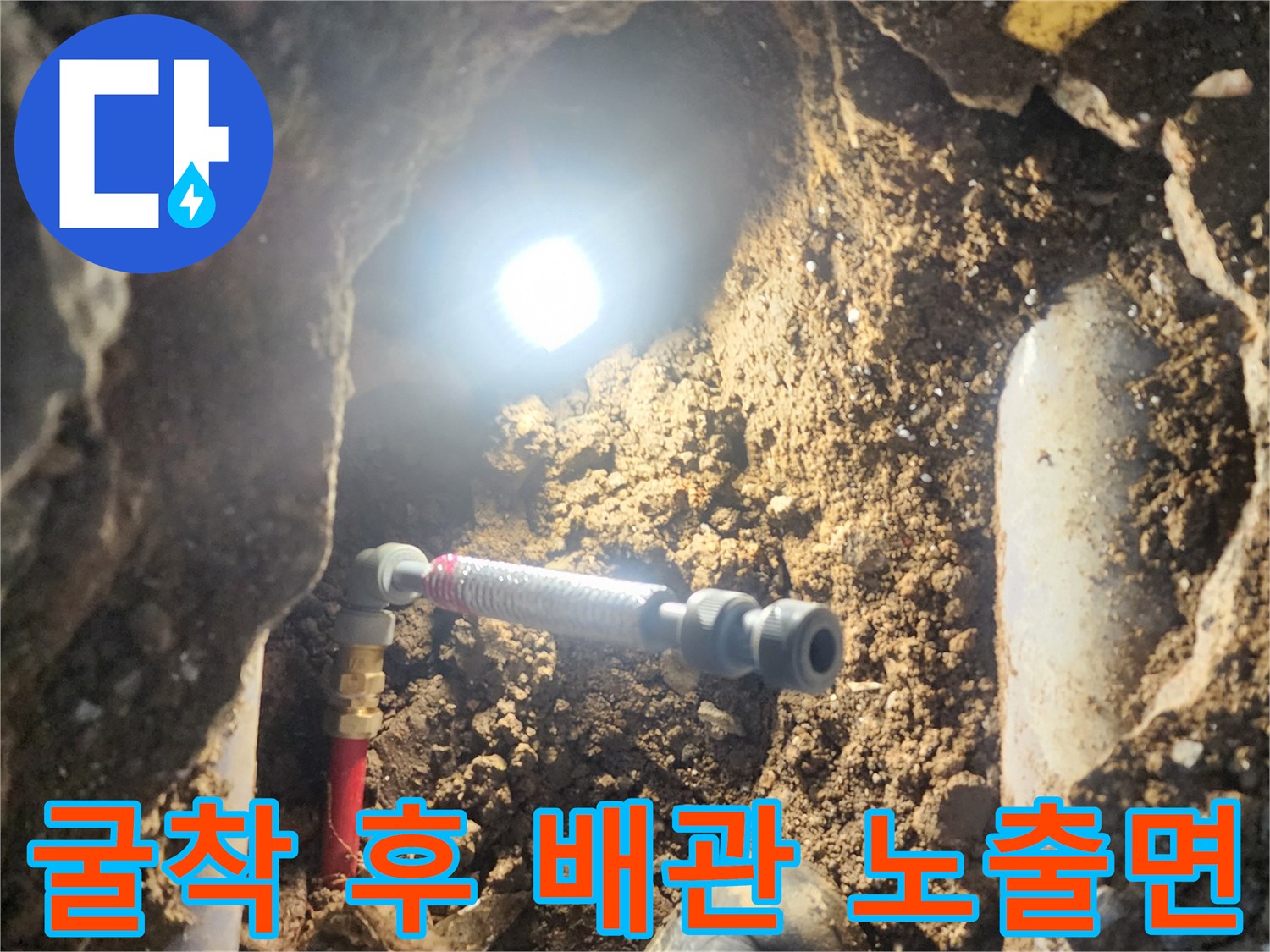 흙과 돌이 섞인 지표면 아래 드러난 배관의 누수부