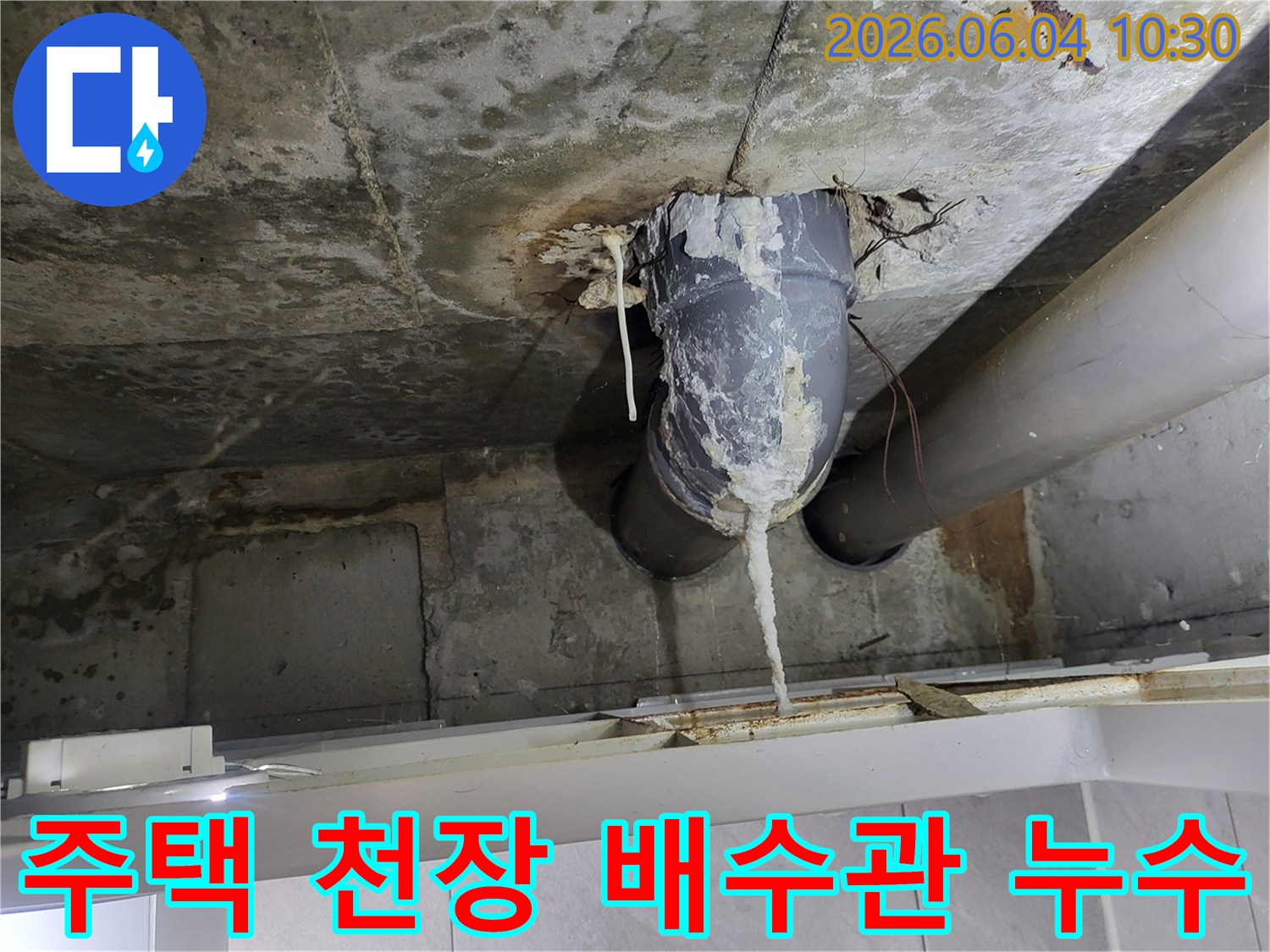 천장 콘크리트와 배수관 연결 부위에서-물이 새어 하얀 석회질이 길게 형성된 모습