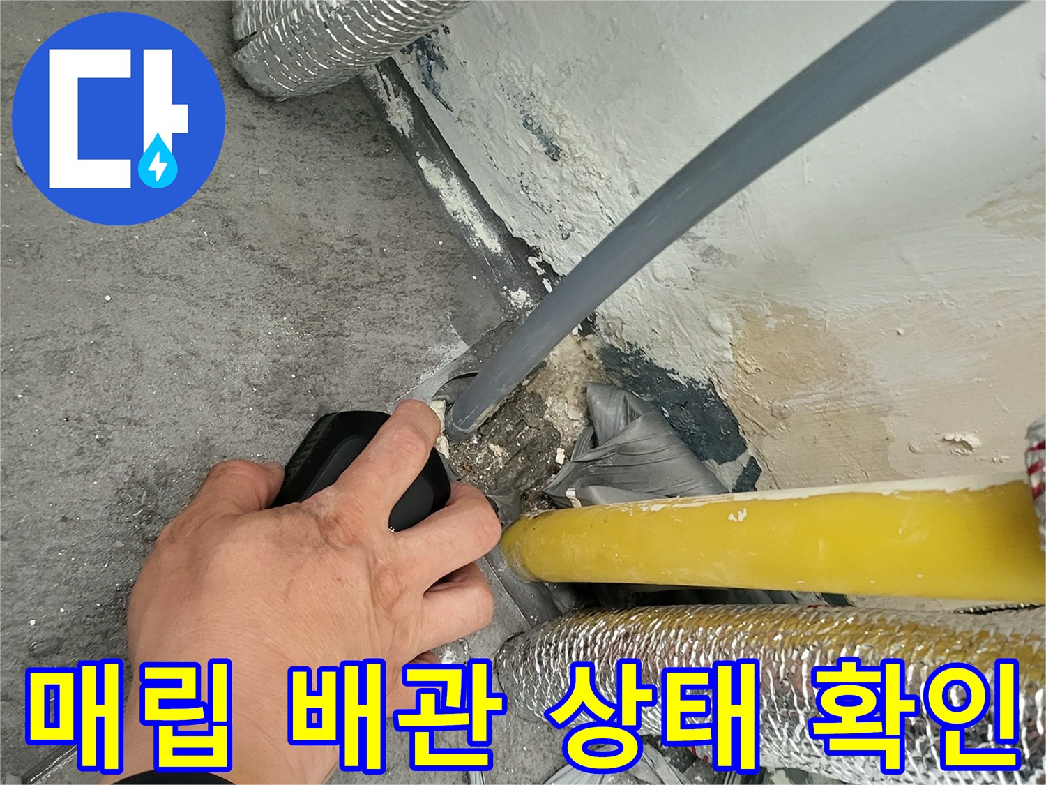 보일러실 바닥 틈새에 위치한 노란색 및 은색 배관 주변 점검