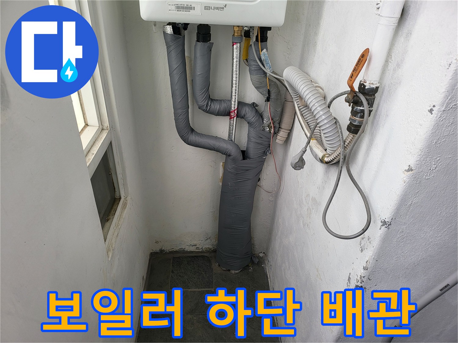 회색 보온재로 덮인 보일러 연결 배관과 벽면 배관 모습