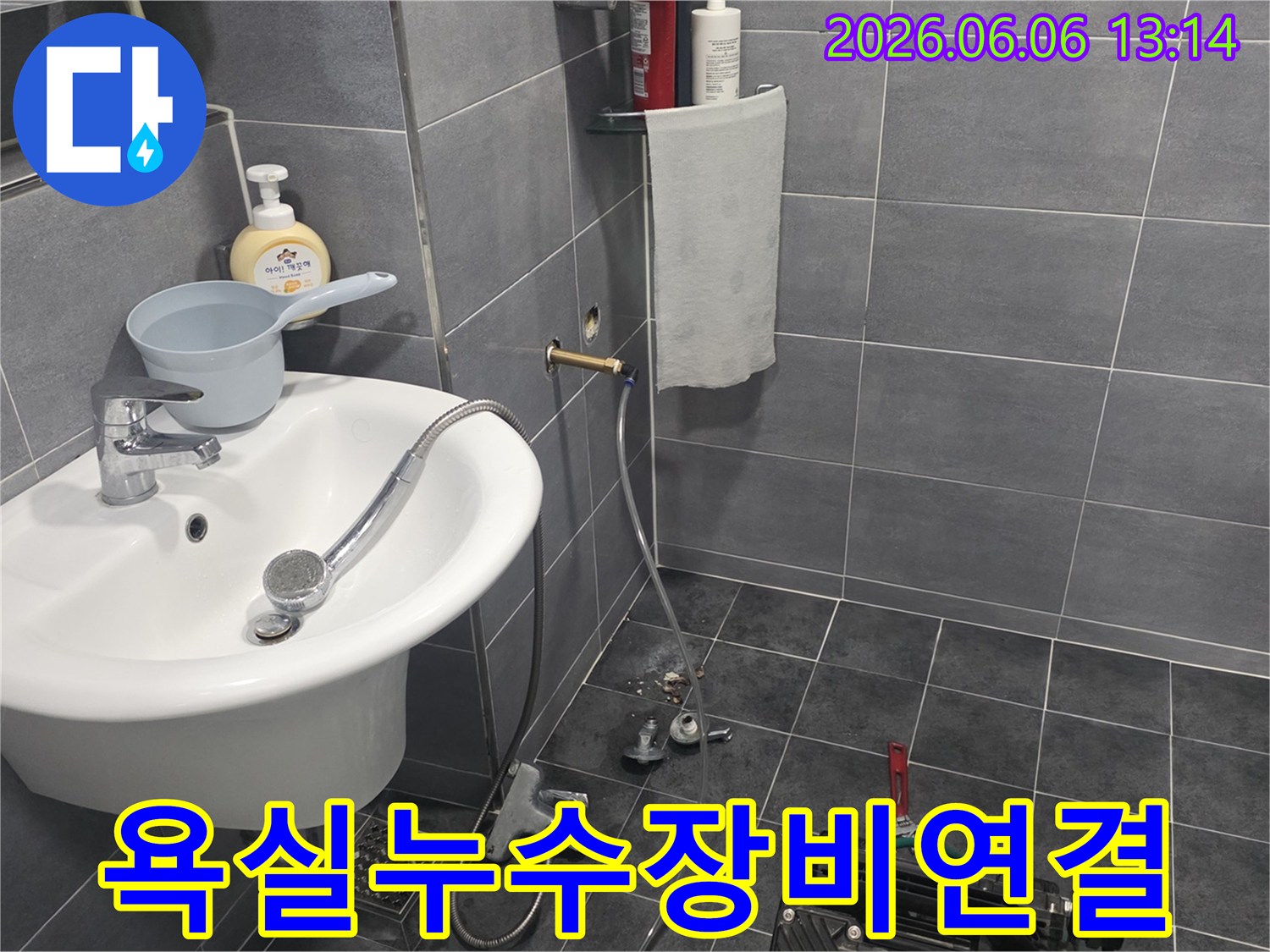 욕실-누수-탐지를-위해-배관에-전문-장비를-연결하고-있는-작업-모습