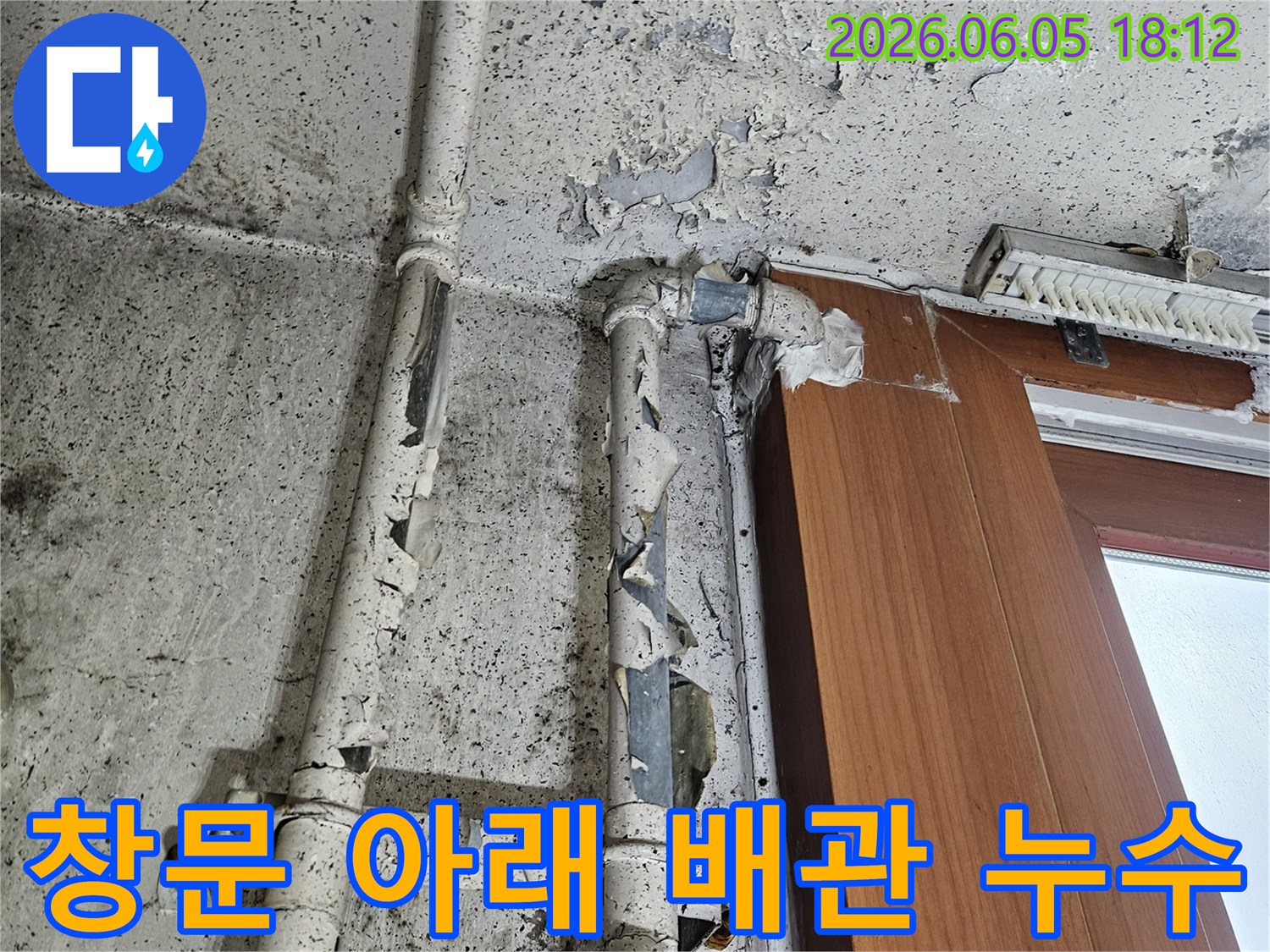 창문 아래 배관에서-물이 새어-벽면 페인트가 벗겨지고-곰팡이가 발생한 모습입니다