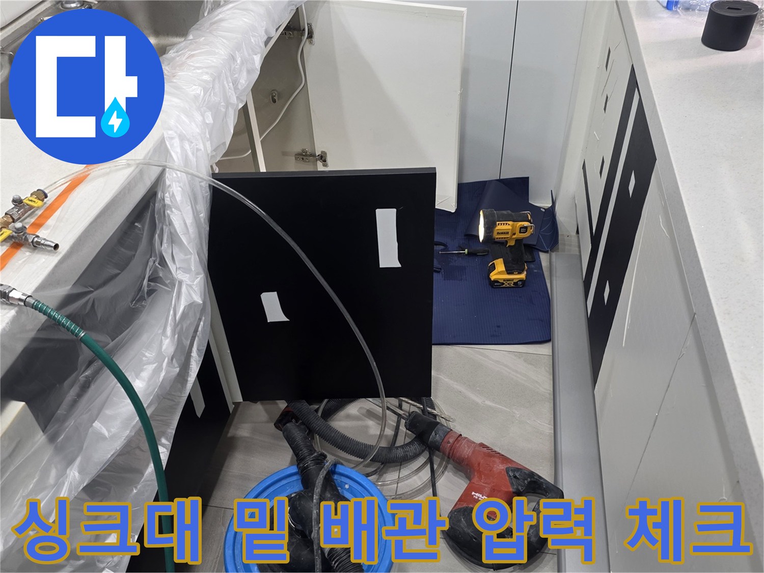 싱크대 하단 공간에 설치된 배관 점검용 디지털 게이지와 연결 호스