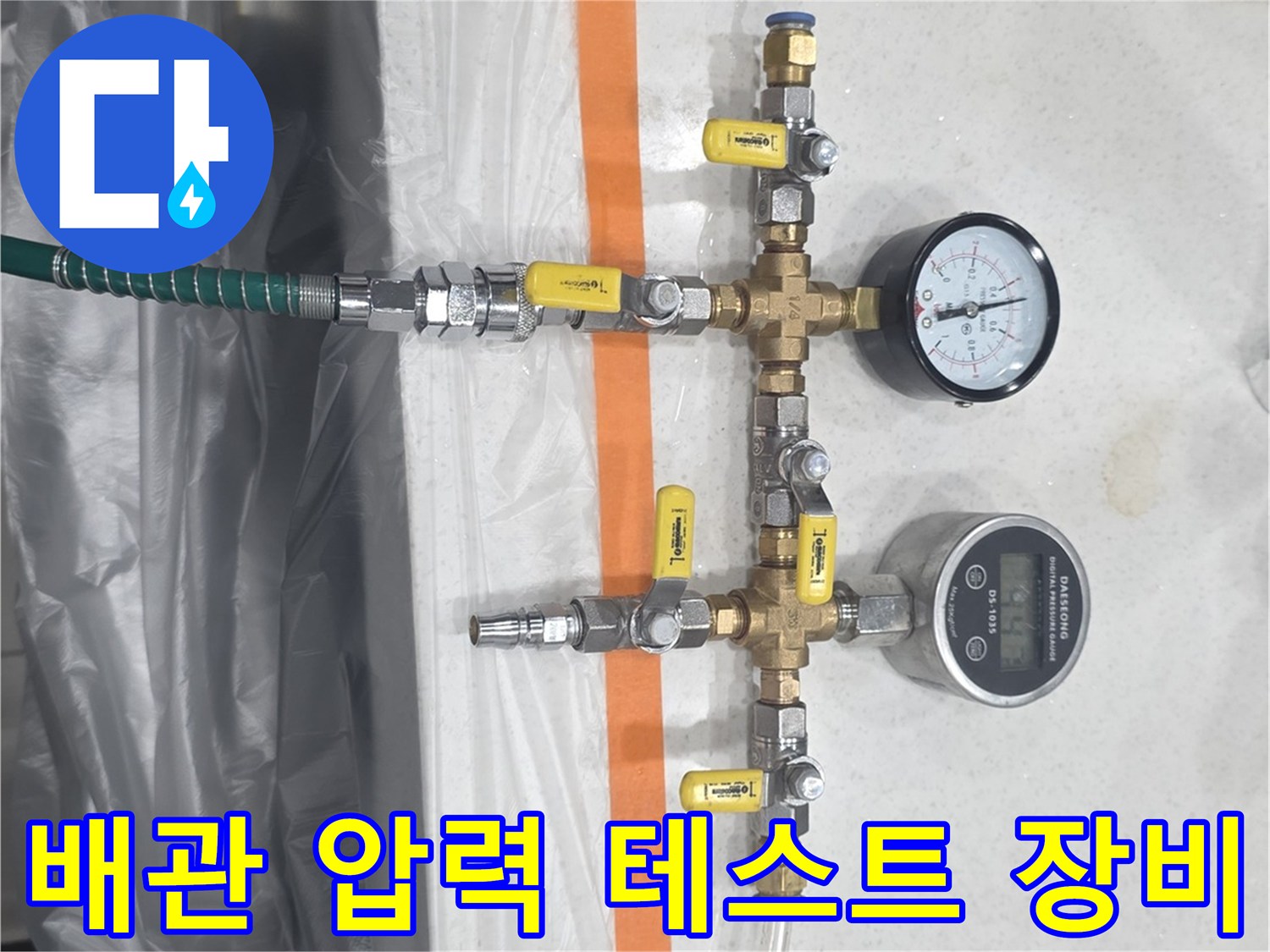 주방 싱크대 하부 배관의 누수 여부를 확인하기 위해 설치된 압력계와 연결 호스
