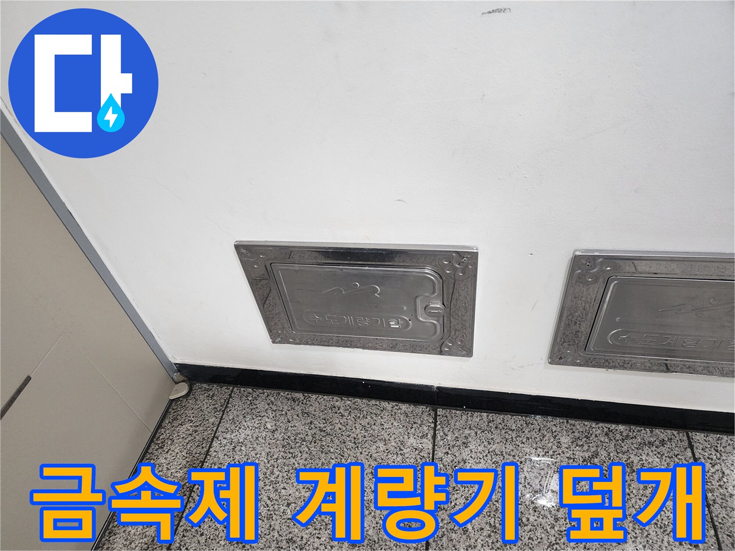 벽면 하단에 위치한-금속 소재의-수도 계량기함 입구
