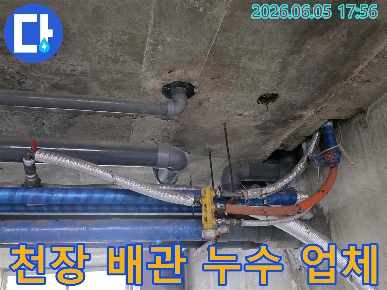 콘크리트-천장-아래-설치된-다양한-배관들의-복잡한-모습-누수-탐지-전문가가-현장을-면밀히-조사하고-있습니다