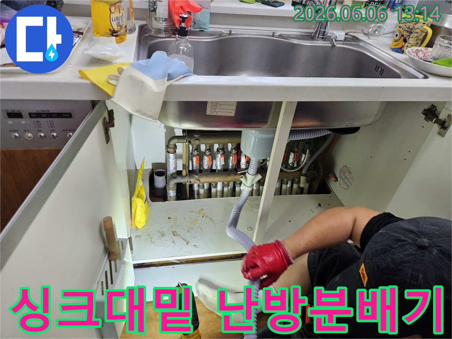 누수-전문가가-싱크대-아래-난방-분배기-주변을-집중적으로-점검하며-누수-흔적을-찾고-있습니다