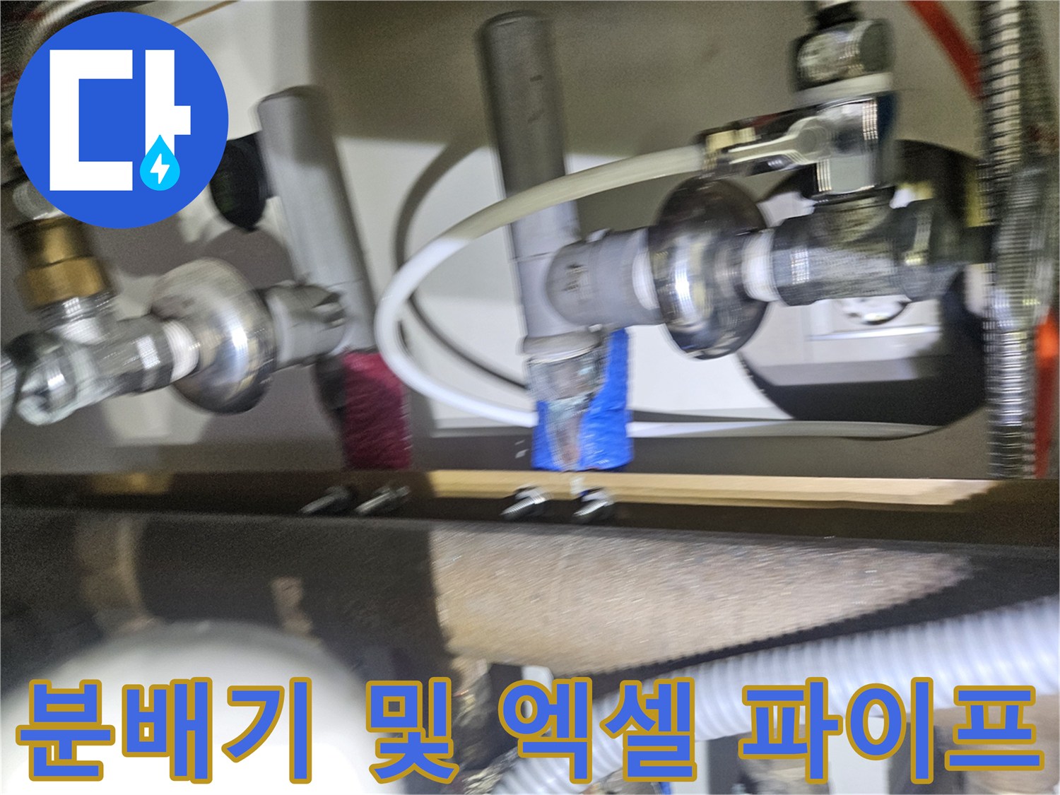 싱크대 하부장 내부에 위치한 난방 분배기와 연결된 배관들의 모습