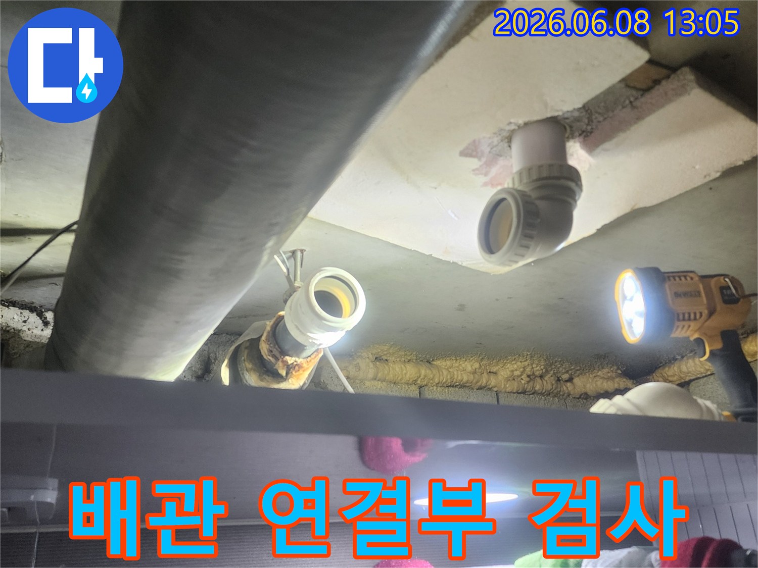 누수-전문가가-어두운-천장-속-배관의-연결-부위를-정밀하게-검사하여-누수-지점을-확인하는-모습