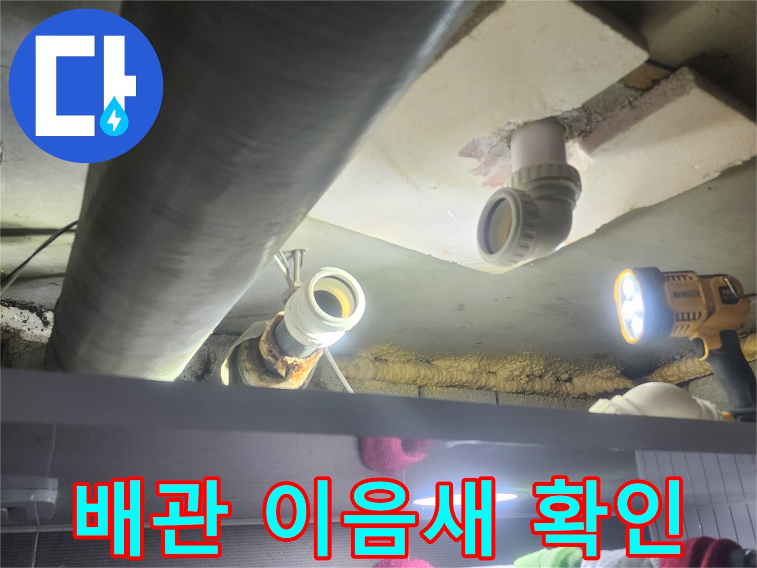 누수-전문가가-어두운-천장-속-배관의-이음새-부분을-집중적으로-확인하며-누수-여부를-판단하는-장면