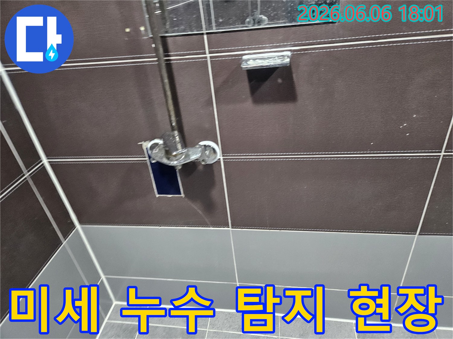 욕실 벽면-샤워기 주변에서-미세한 누수 지점을-전문 장비로-탐지하는 엔지니어의 모습
