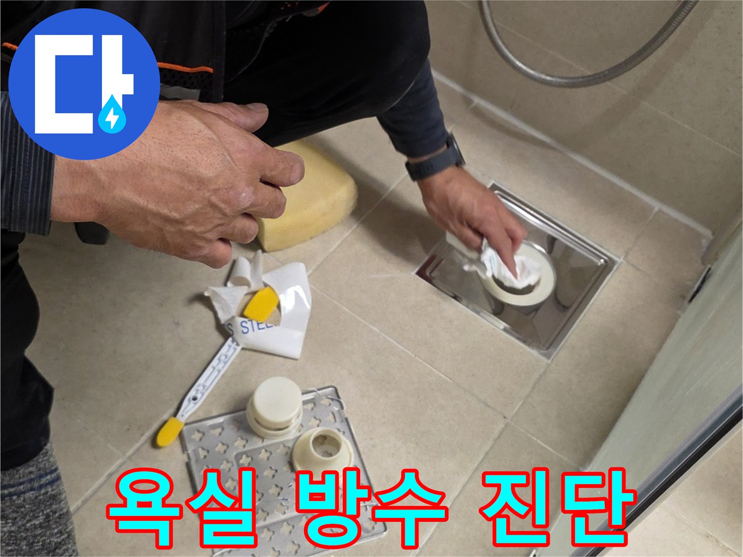 작업자가 화장실-바닥 배수구 주변의 누수 지점을 정밀하게 점검함