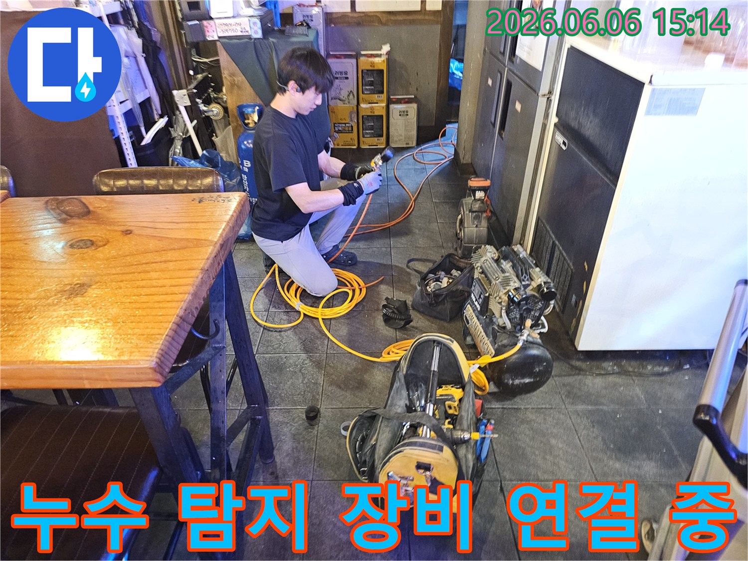 전문 엔지니어가-상업 공간의 누수 문제를 해결하기 위해-탐지 장비를 연결하고 있습니다.