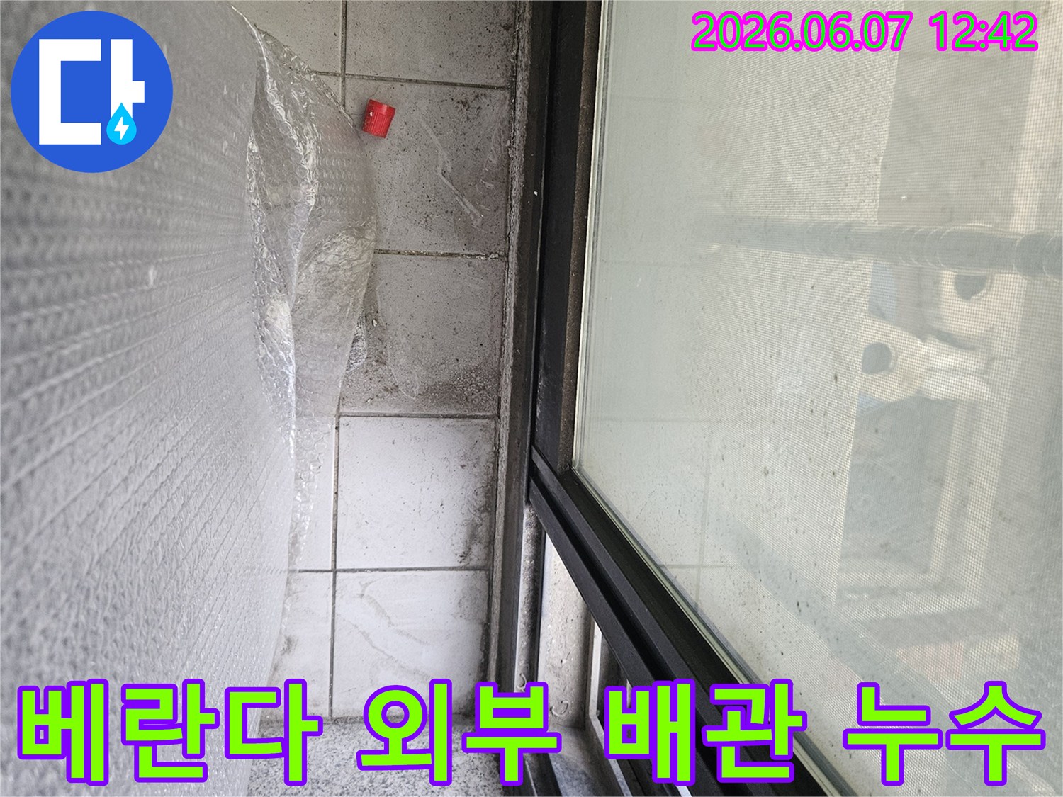 이 이미지는-베란다 외부 배관 주변에서 발생한-누수 문제를 정밀 보수하기 위한-공사 준비 현장입니다