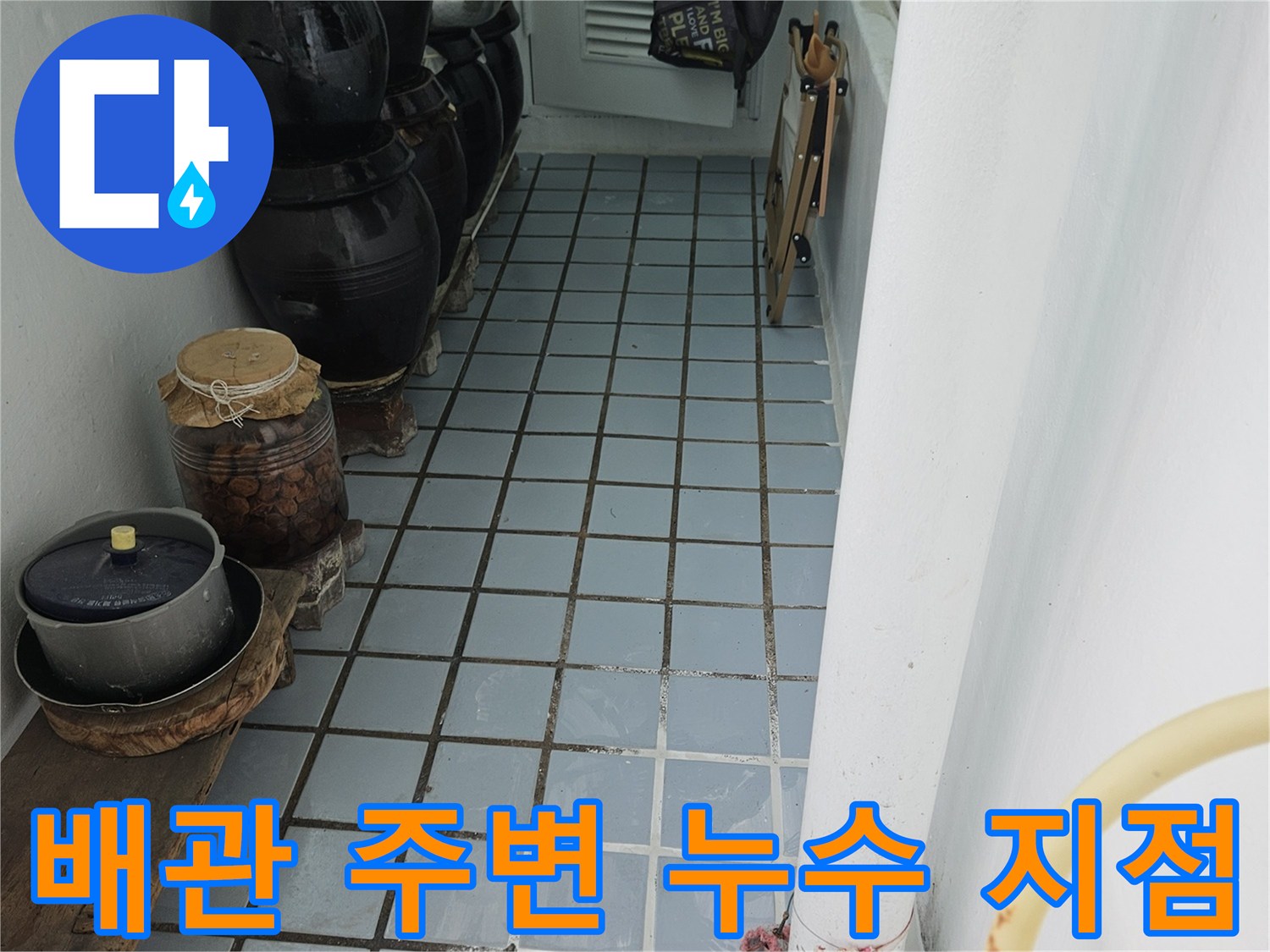 하얀색 배관과 타일이 만나는 지점의 틈새를 집중적으로 촬영한 사진입니다.