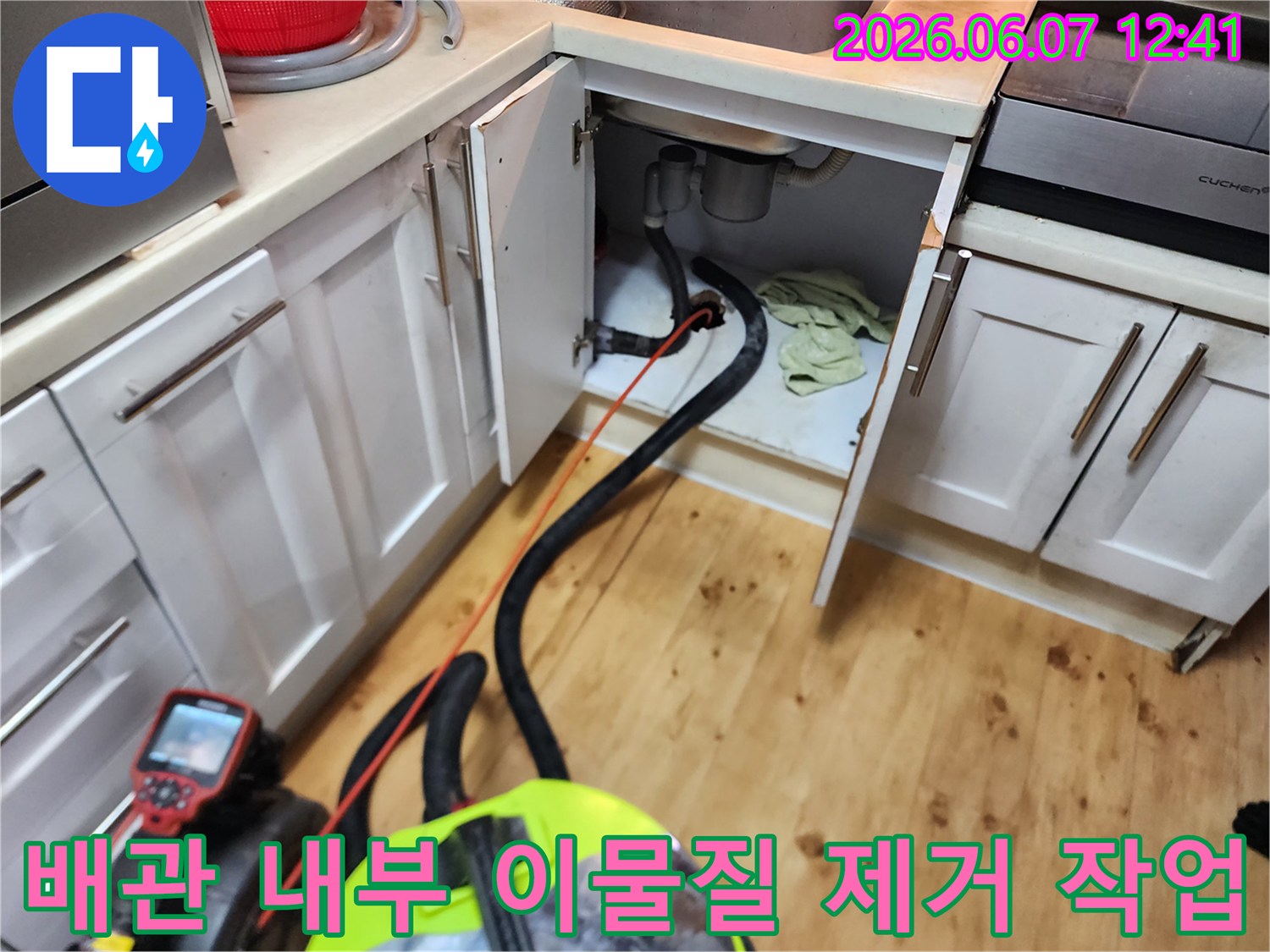 싱크대 하부 배관에 연결된 석션 호스를 통해 오수를 흡입하는 장면입니다.