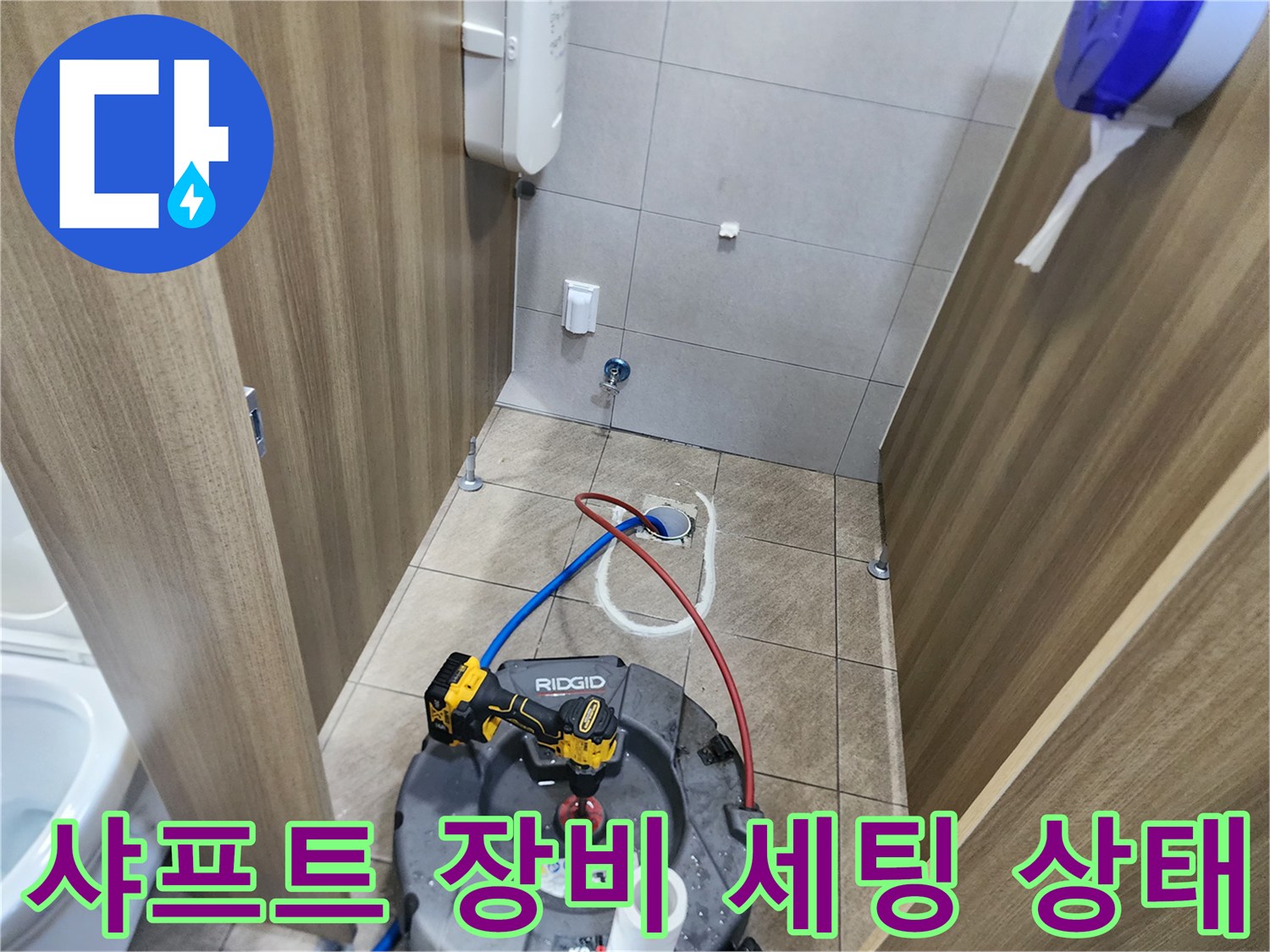 변기 탈거 부위 근처에-배관 청소용 샤프트 기계를 배치하여 작업을 진행 중입니다.