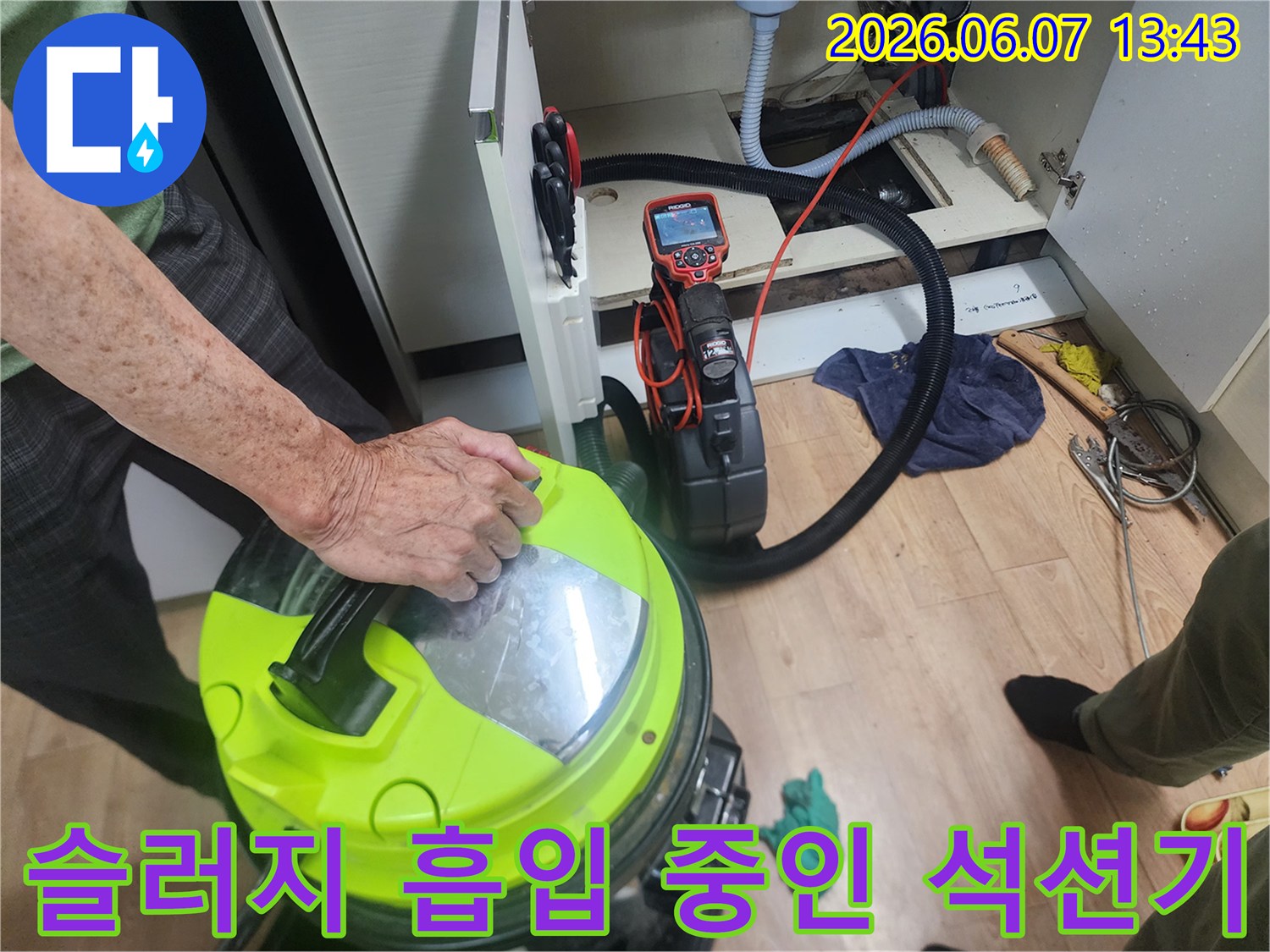 석션기를 이용한 배관 이물질 제거-싱크대 하부 배관 내부의 찌근거리를 흡입하는 장면
