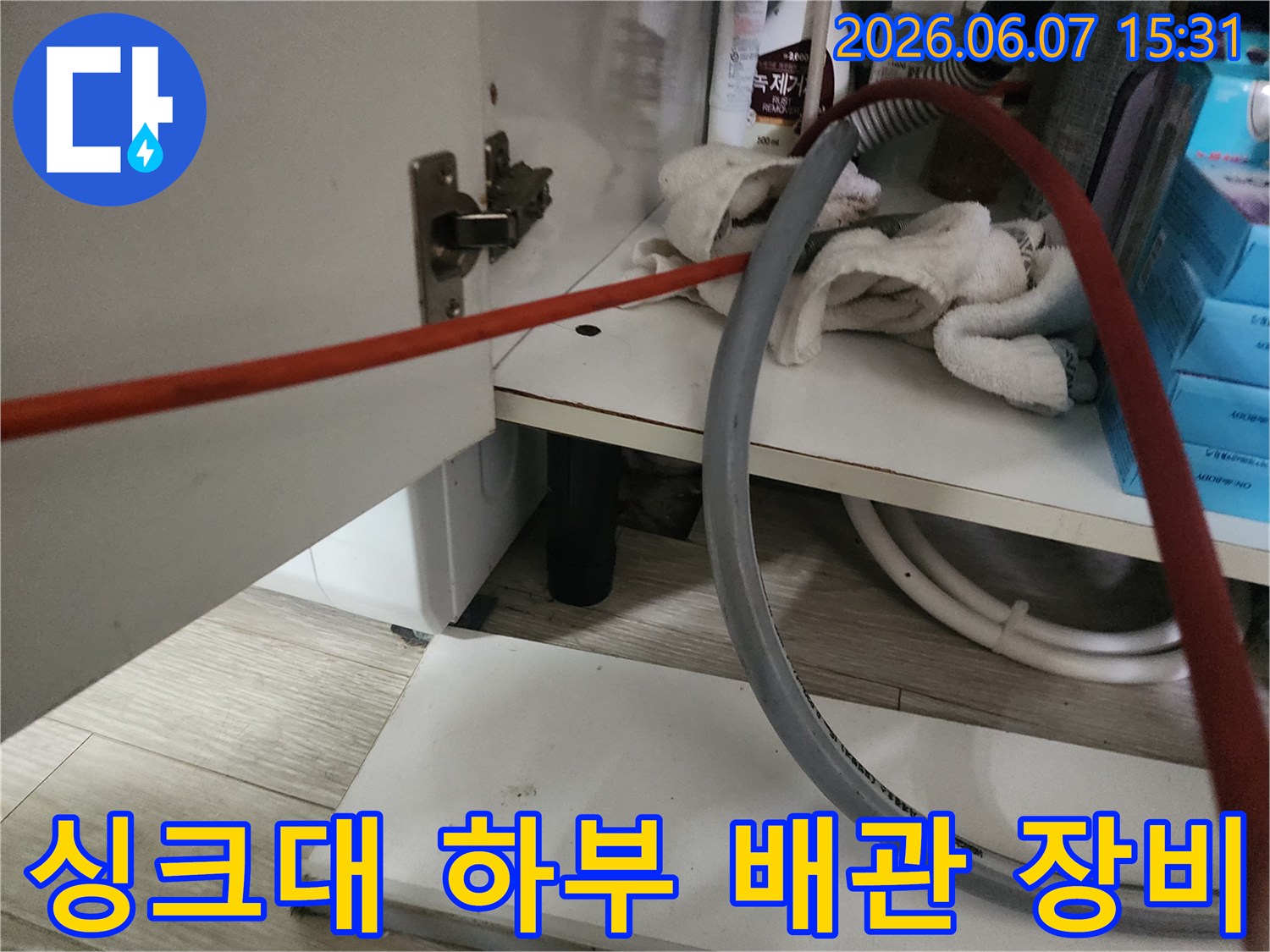 싱크대 밑 공간에 배치된 작업용 호스와 청소 도구들