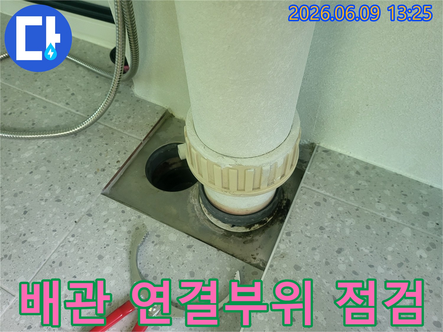 욕실 배관 연결 부위에서-누수 흔적이 발견되어-전문가가 정밀 점검을-시작하는 모습입니다