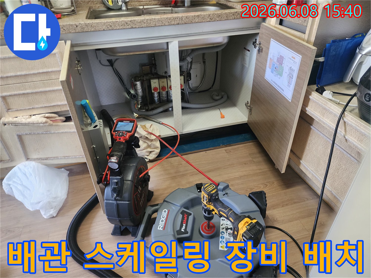 싱크대 하부 배관 청소를 위해 설치된 내시경 카메라와 석션 호스