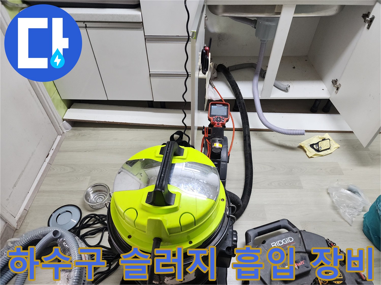 싱크대 밑 작업 현장에 놓인 석션기 및 부속품