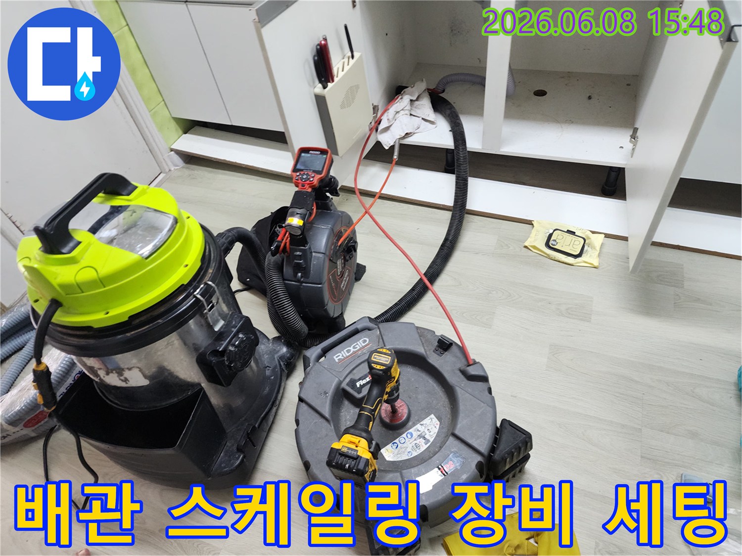 싱크대 하부장 아래에 배치된 배관 스케일링 및 석션 장비들