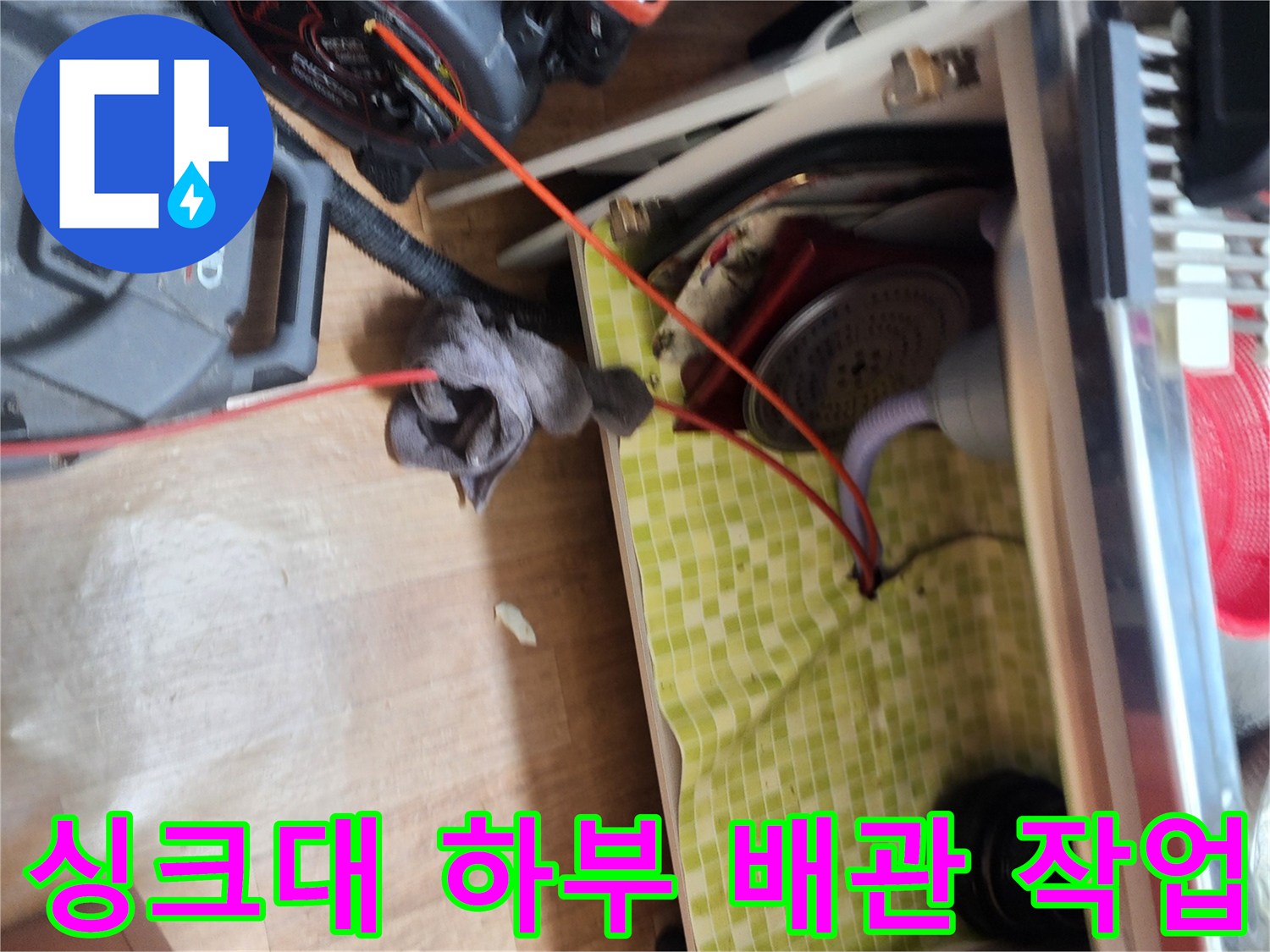 도봉구 싱크대 하부의 막힌 배관을 뚫기 위해 스케일링 장비를 운용하는 모습입니다.