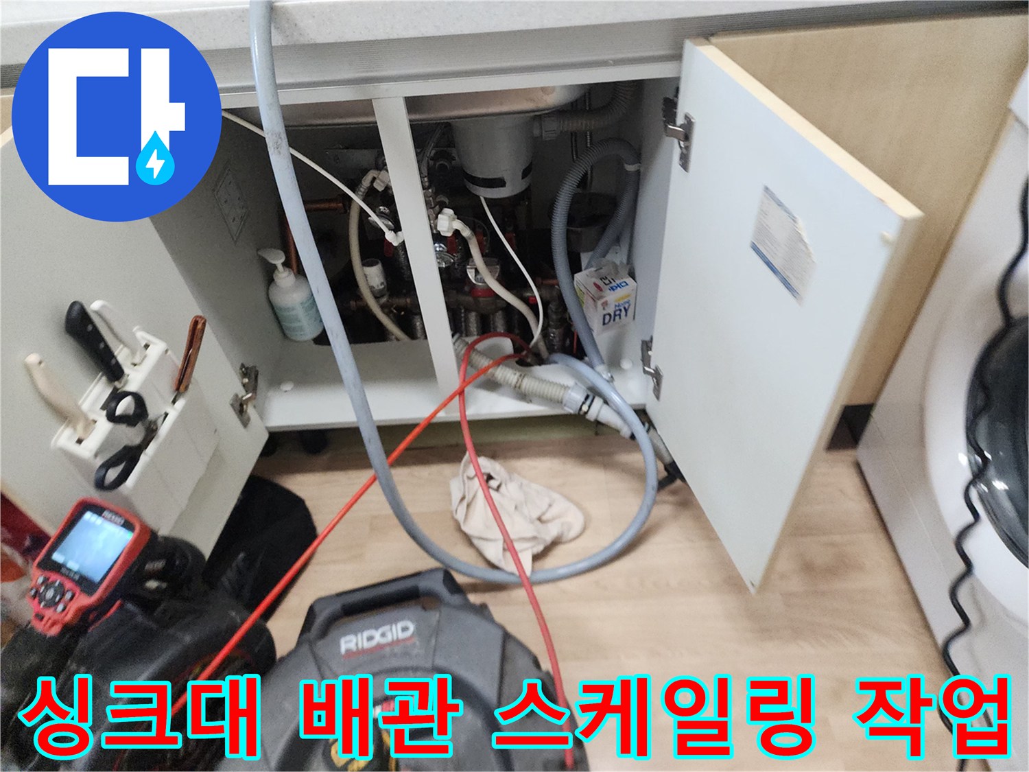 싱크대 하부 배관의 이물질을 제거하기 위해 장비를 투입하는 과정