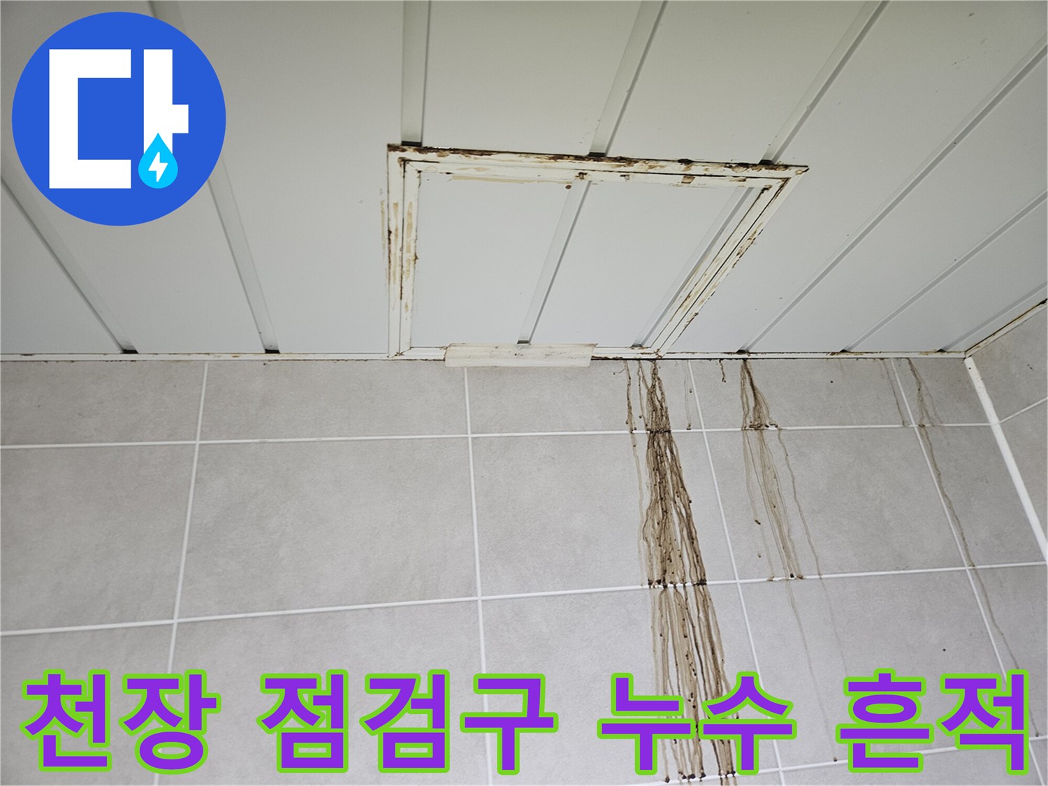 천장 점검구 주변의 누수 얼룩과 타일 벽면을 타고 흐른 물길 흔적