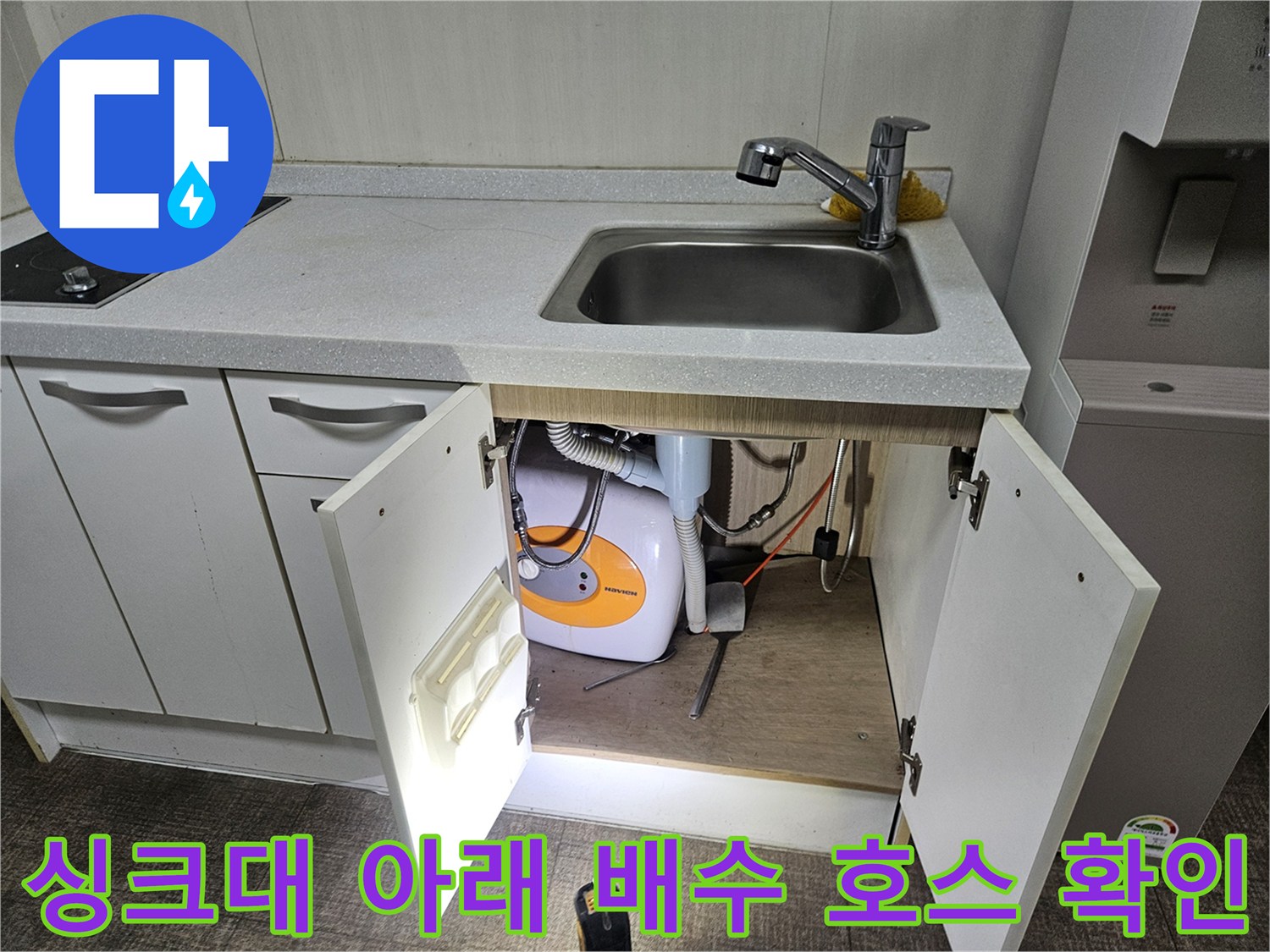 하부장 내부의 세탁기 배수관과 싱크대 수전 부속 상태