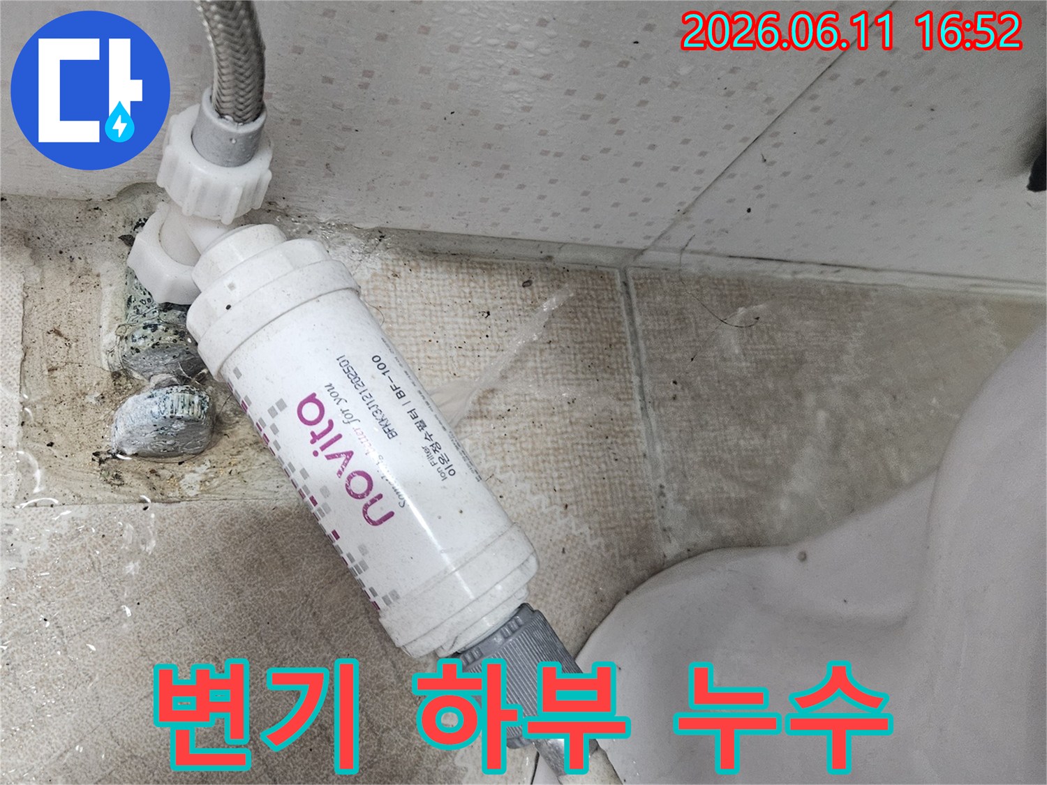 변기 옆에 설치된 정수 필터에서-물이 새어 나와-바닥을 적시고 있는-누수 현장을 보여주는 이미지