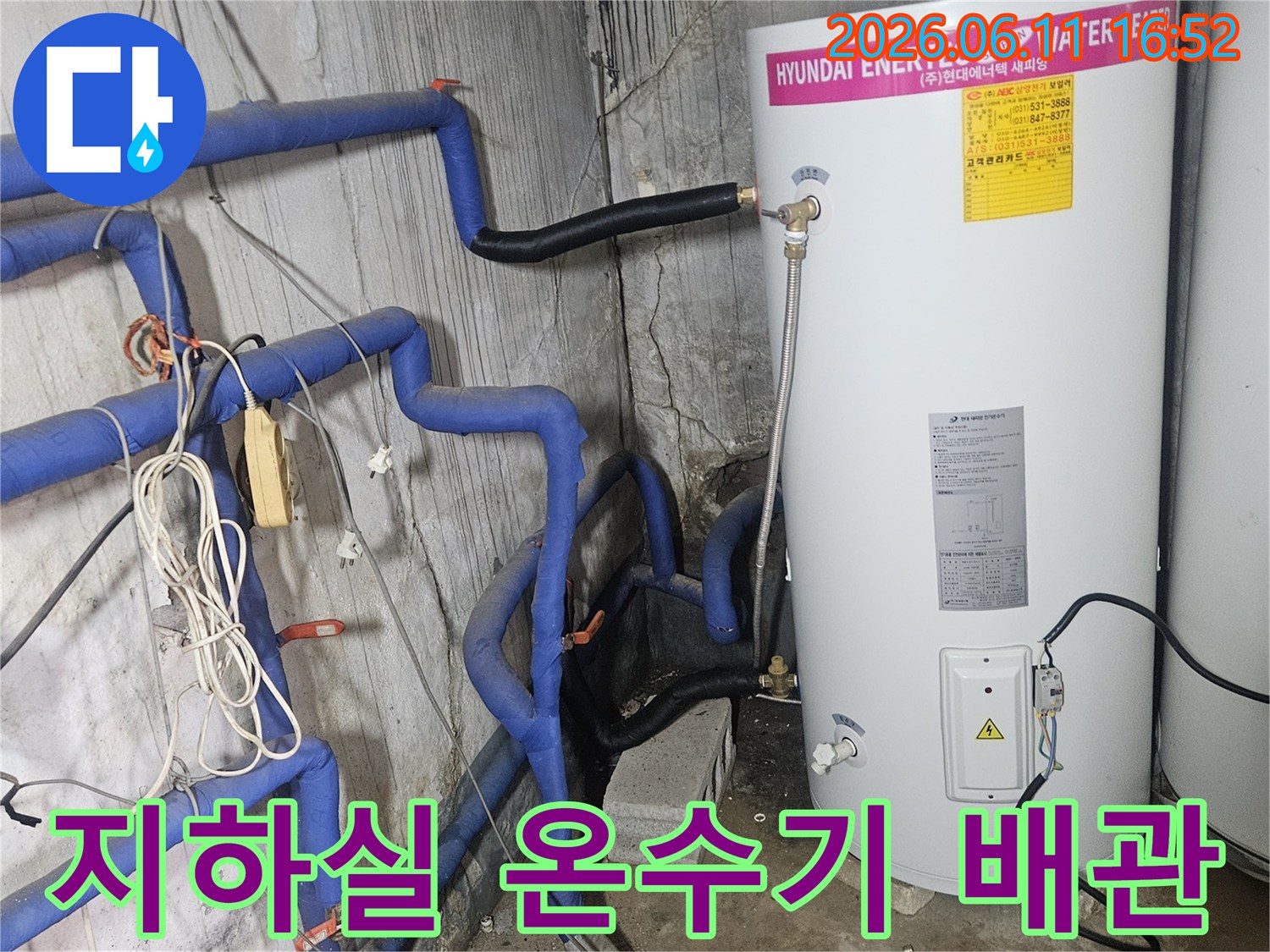 보일러실-내부의-온수기-및-파란색-보온재로-감싸인-배관-시스템을-자세히-보여줍니다.