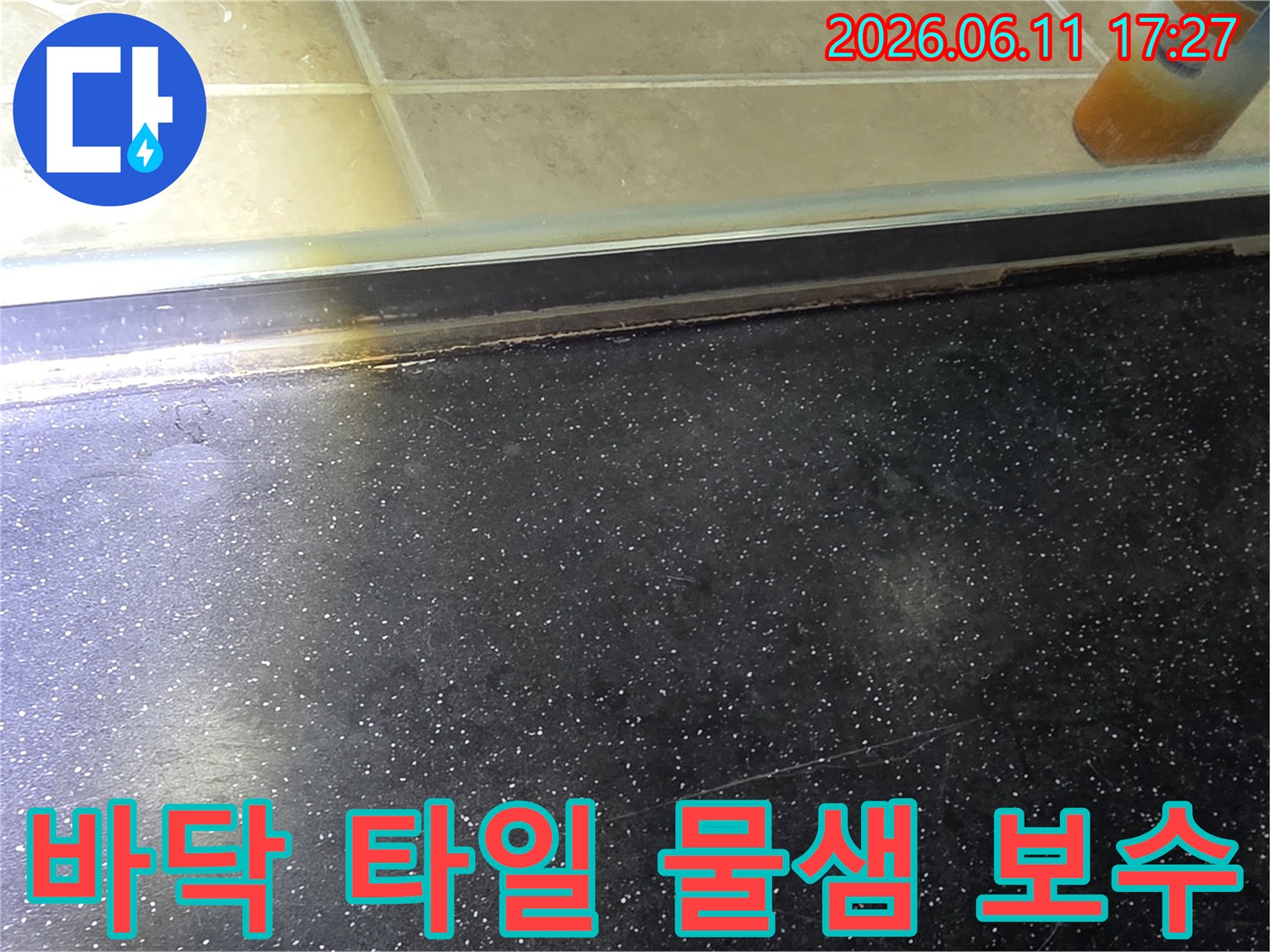 화장실 바닥 타일 틈새와 샤워부스 경계면에서 발생한 물샘 흔적을 보수하기 전 모습
