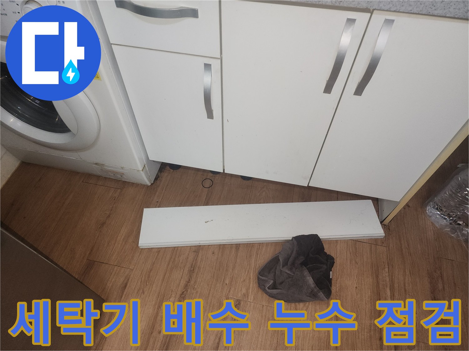 주방-세탁기-배수-누수로-인한-바닥-물고임-현상을-조사하기-위해-싱크대-하부-걸레받이를-제거하고-내부를-살피는-장면입니다