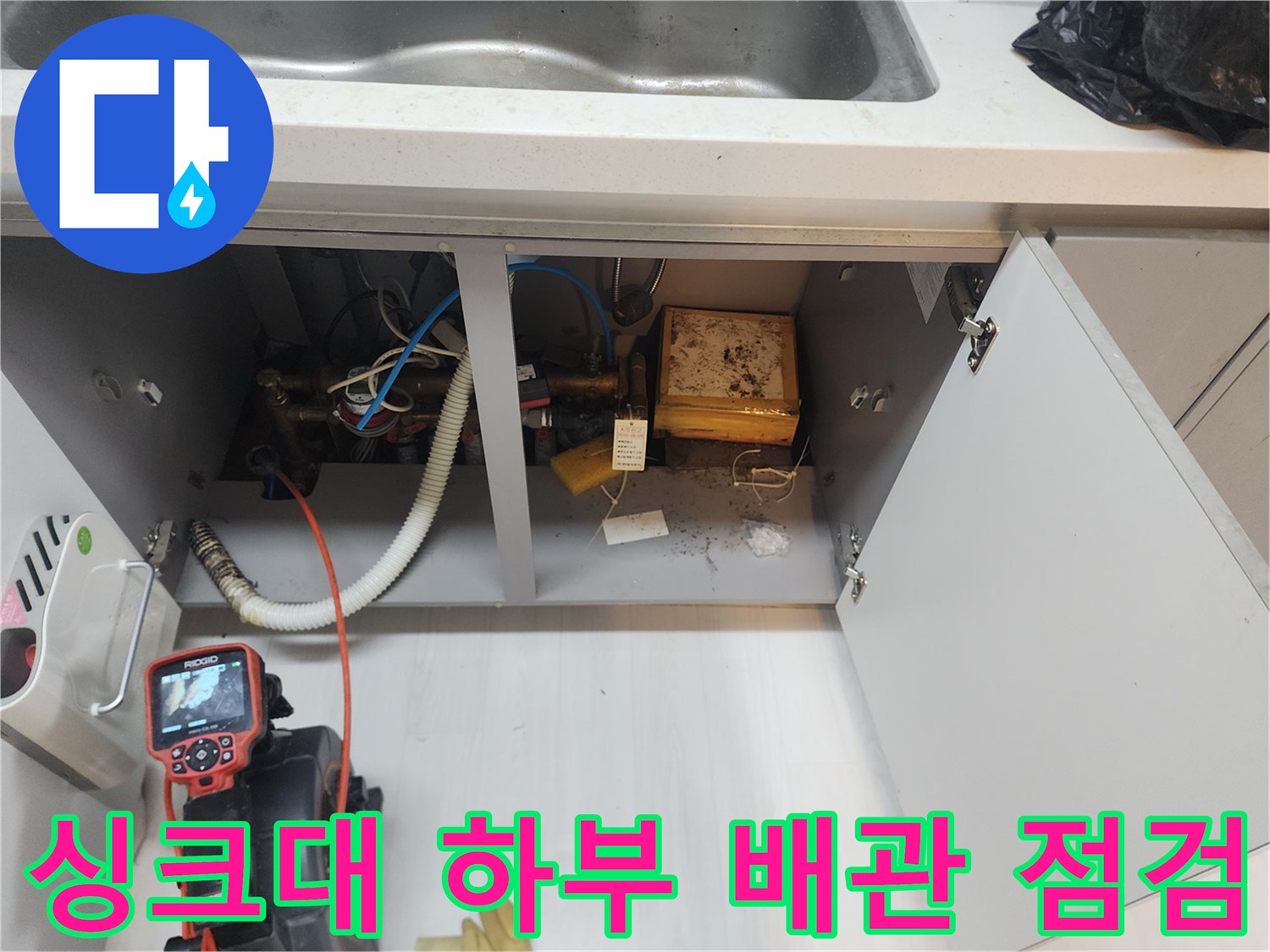 일산동구 식사동 싱크대 하부장 내부의 배수 호스와 배관 연결 상태를 확인하는 모습