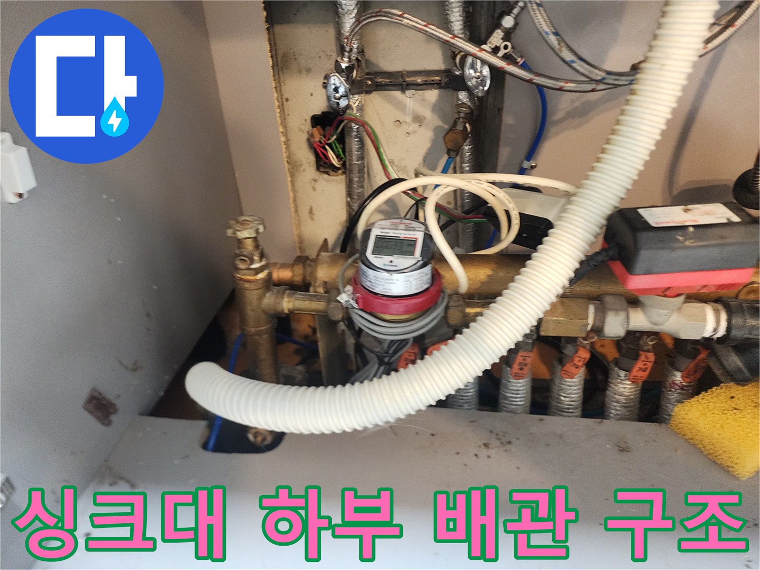 강북구 수유동-주방 싱크대 하단에 복잡하게 연결된 배관과 계량기 모습입니다.